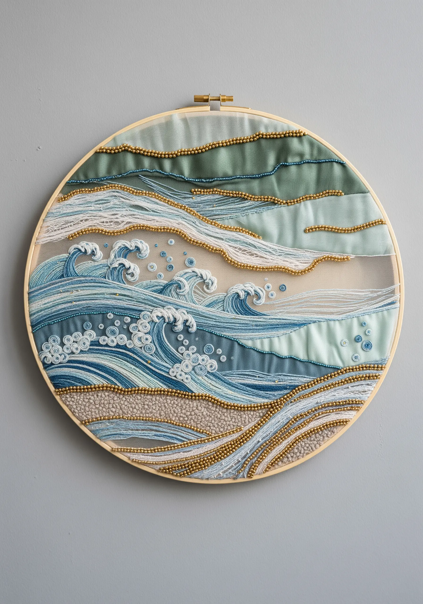 Ocean wave embroidery hoop using layered fabrics, beading for texture, and delicate line work.