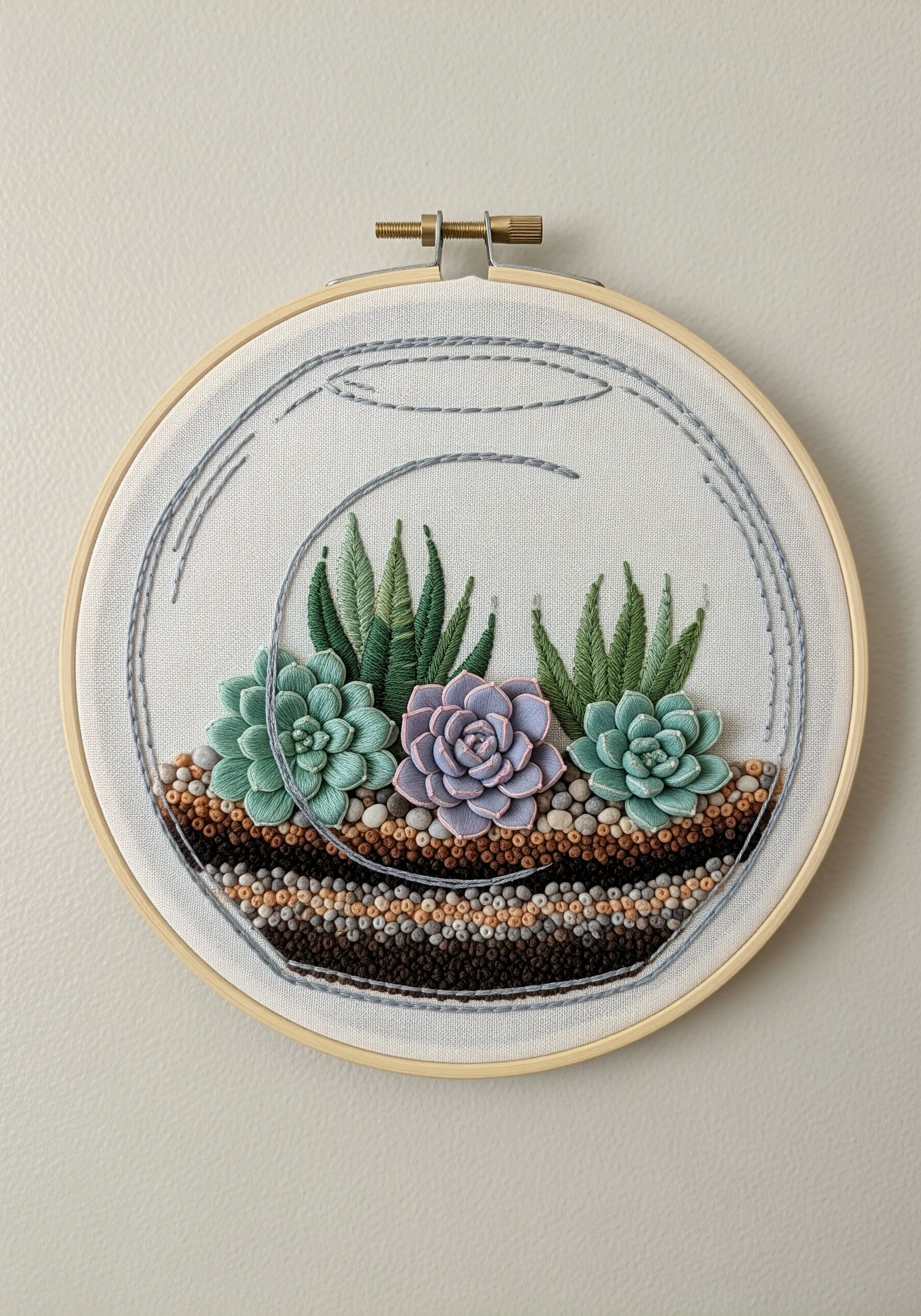 Embroidered terrarium with 3D succulents and French knot soil layers.