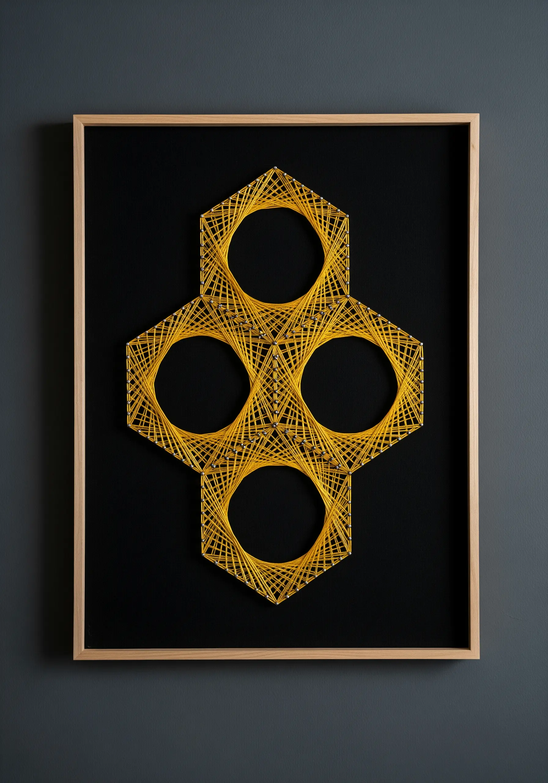 A geometric string art piece with interconnected yellow hexagons on a black background.