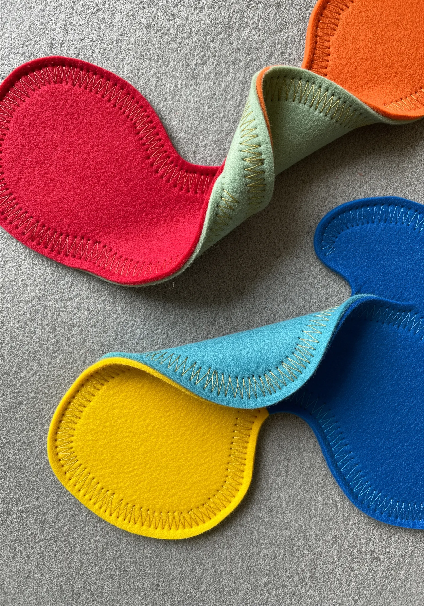 Colorful pieces of felt folded and stitched together to create abstract, biomorphic shapes.