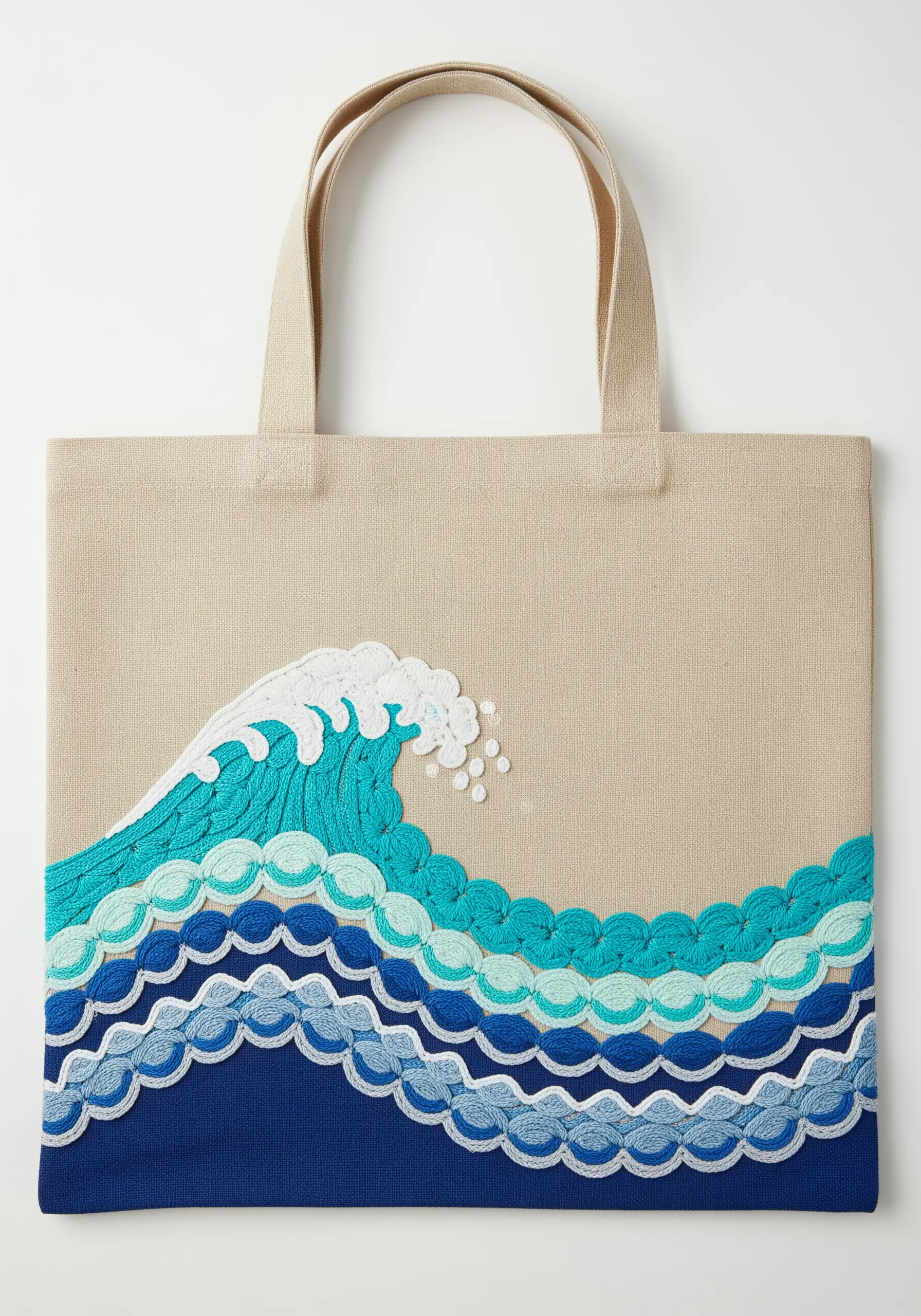 A stylized ocean wave made of layered, scalloped stitches in shades of blue.