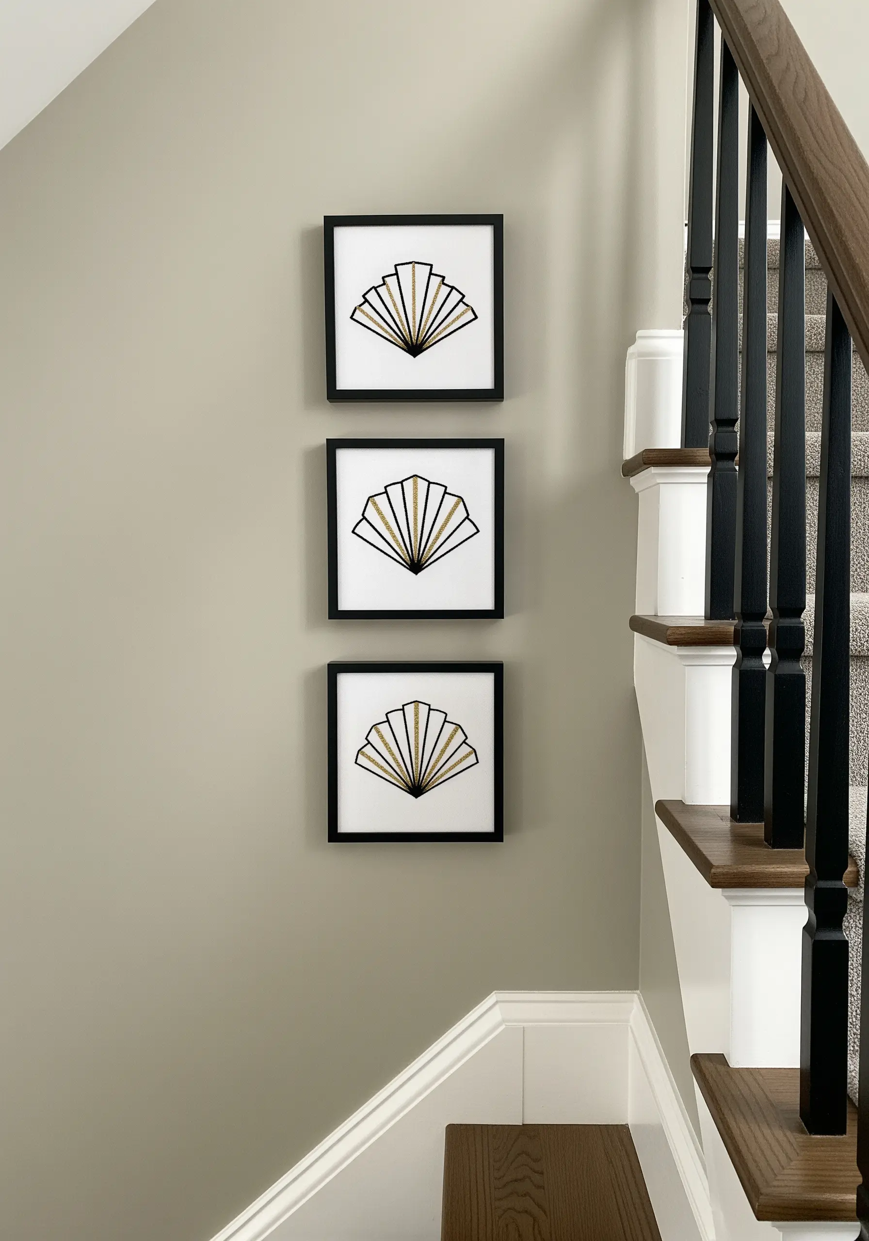 Three square frames in a vertical line, each with an Art Deco fan embroidered in gold and black.