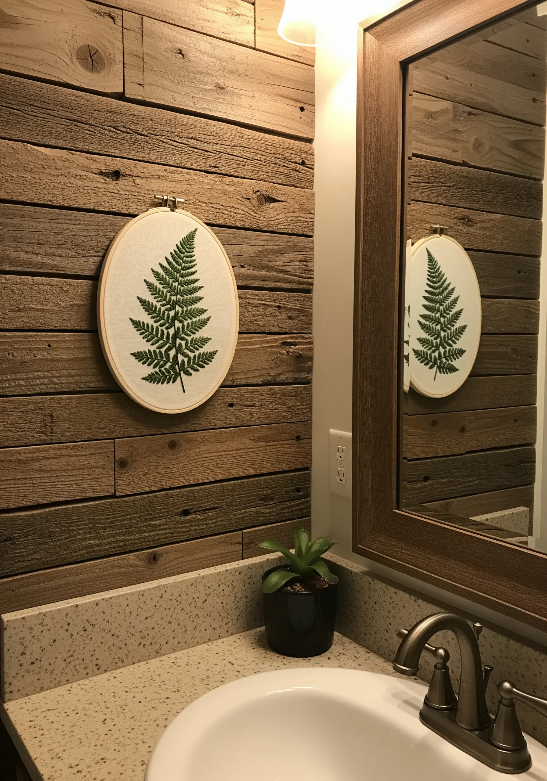 A detailed fern leaf embroidered in fishbone stitch on off-white fabric.