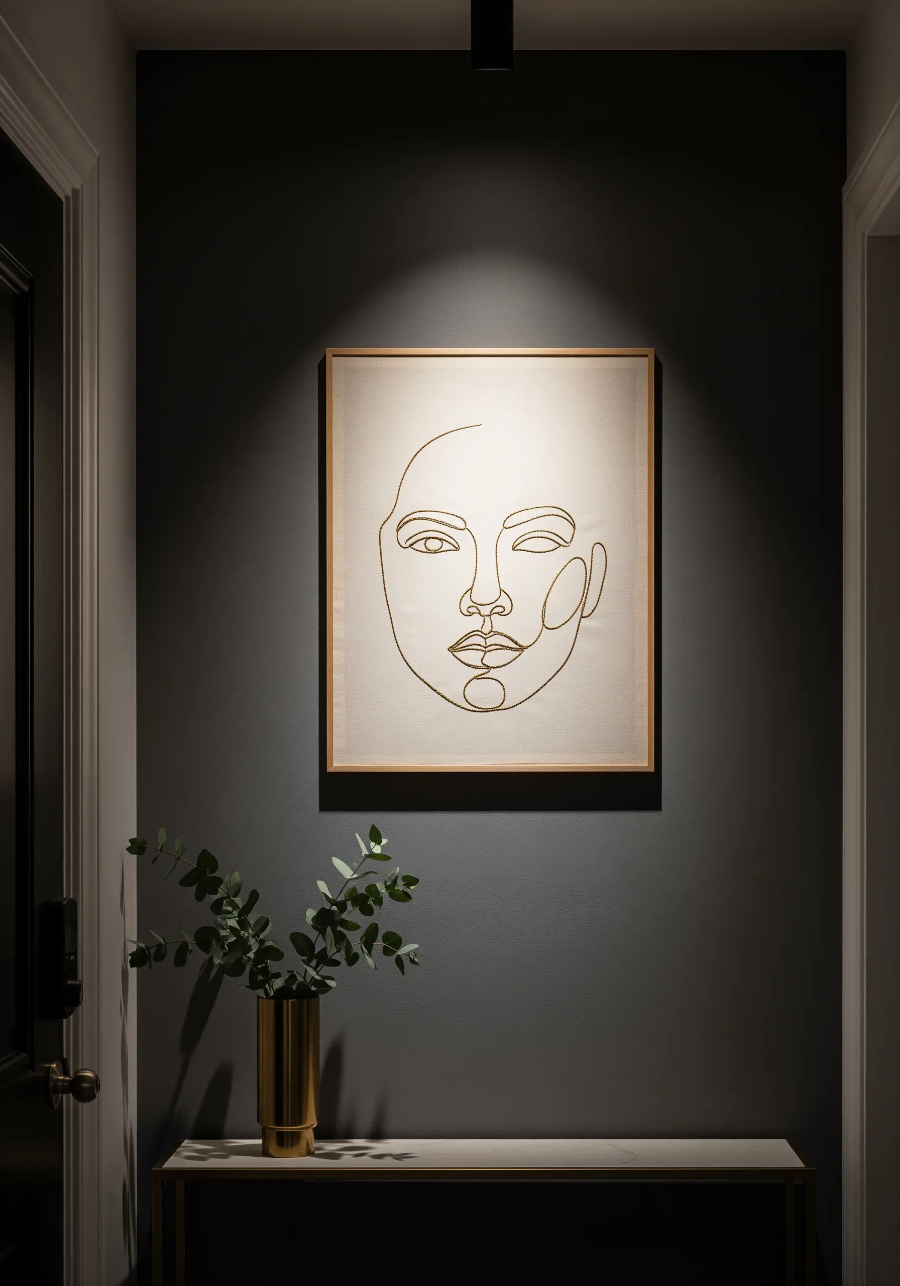 A minimalist single-line portrait of a face embroidered in a square wooden frame.