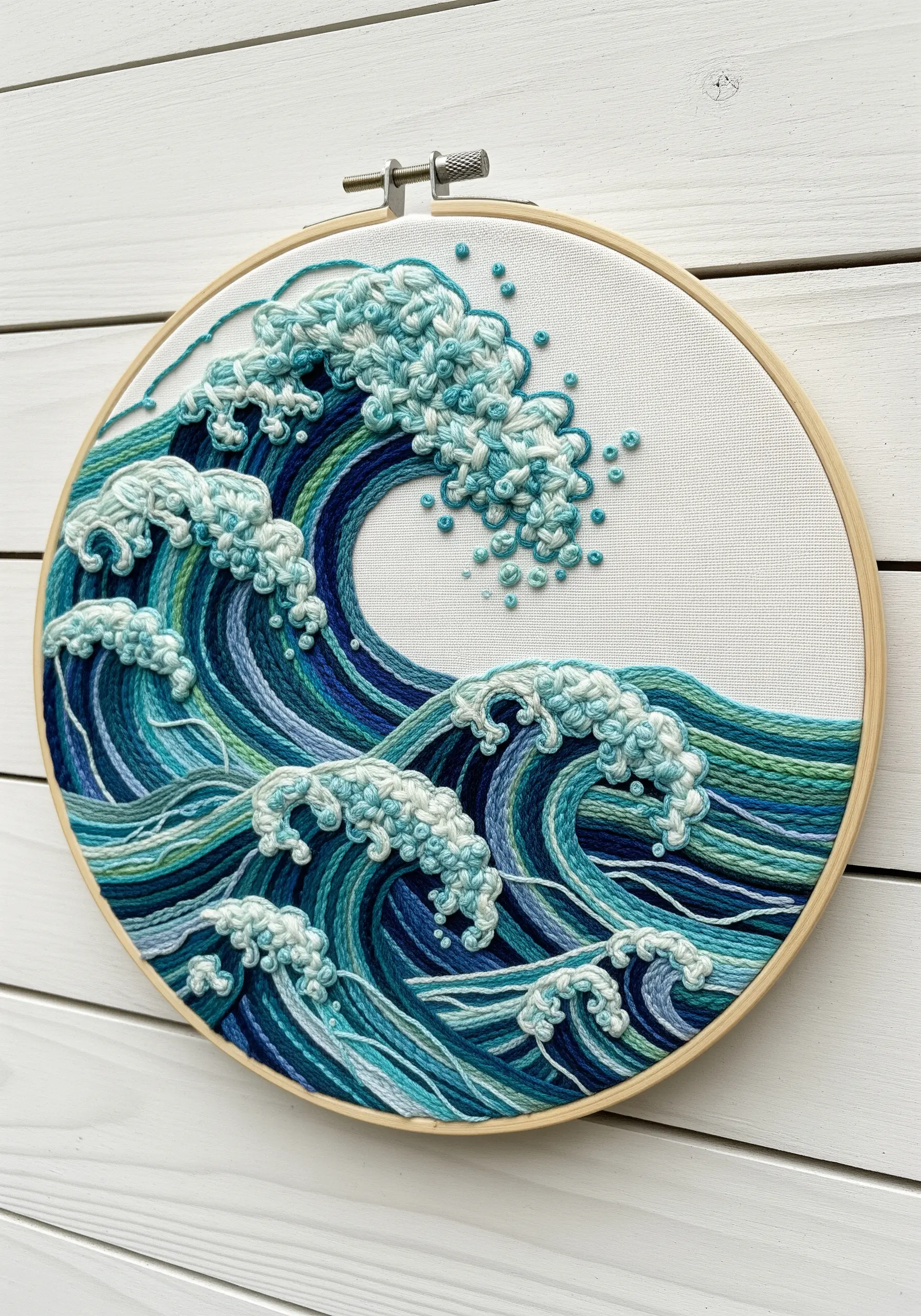 An embroidered ocean wave with textural French knots for foam and directional stitches for water.