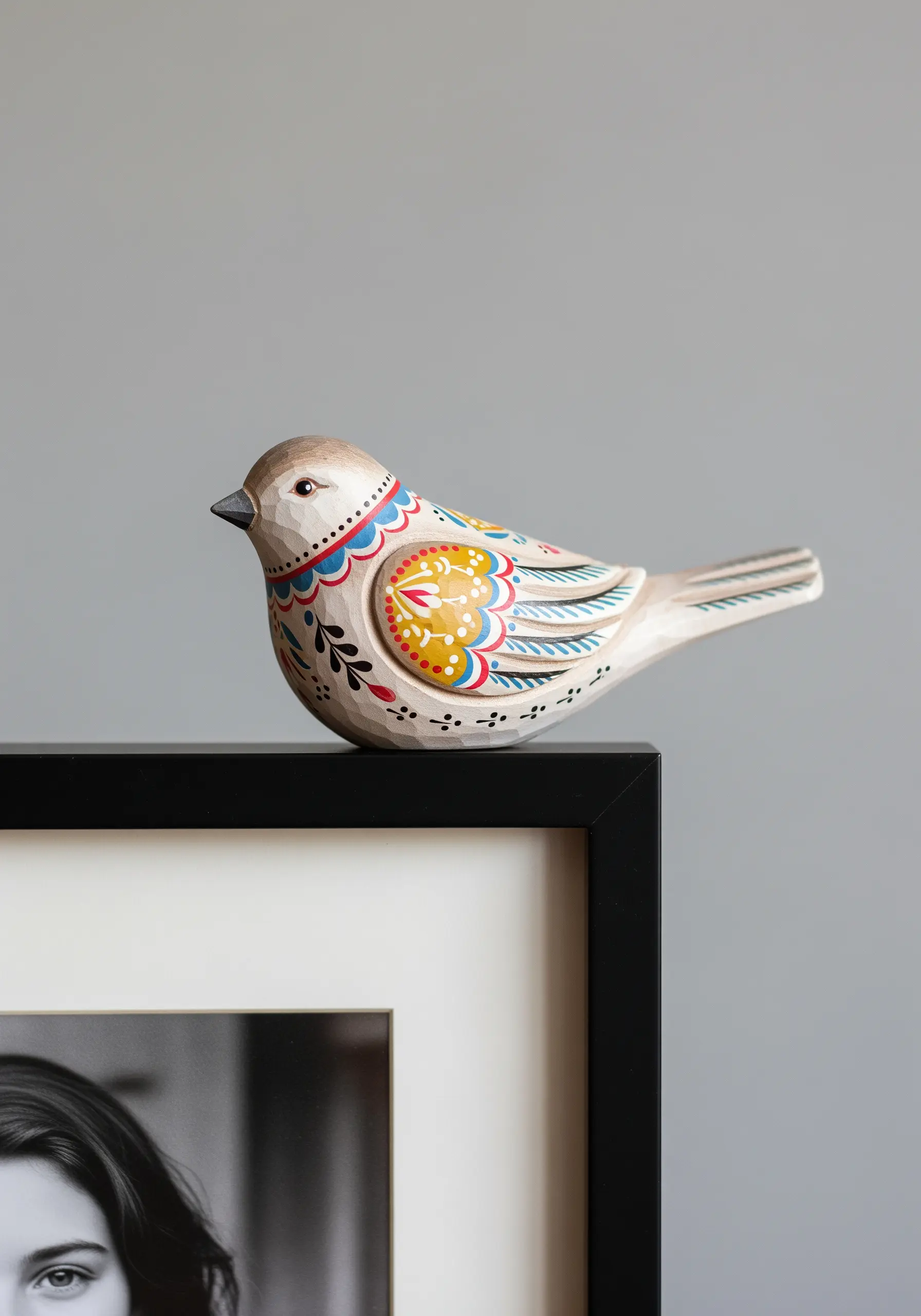 A small, carved wooden bird with colorful folk art patterns on its wings.