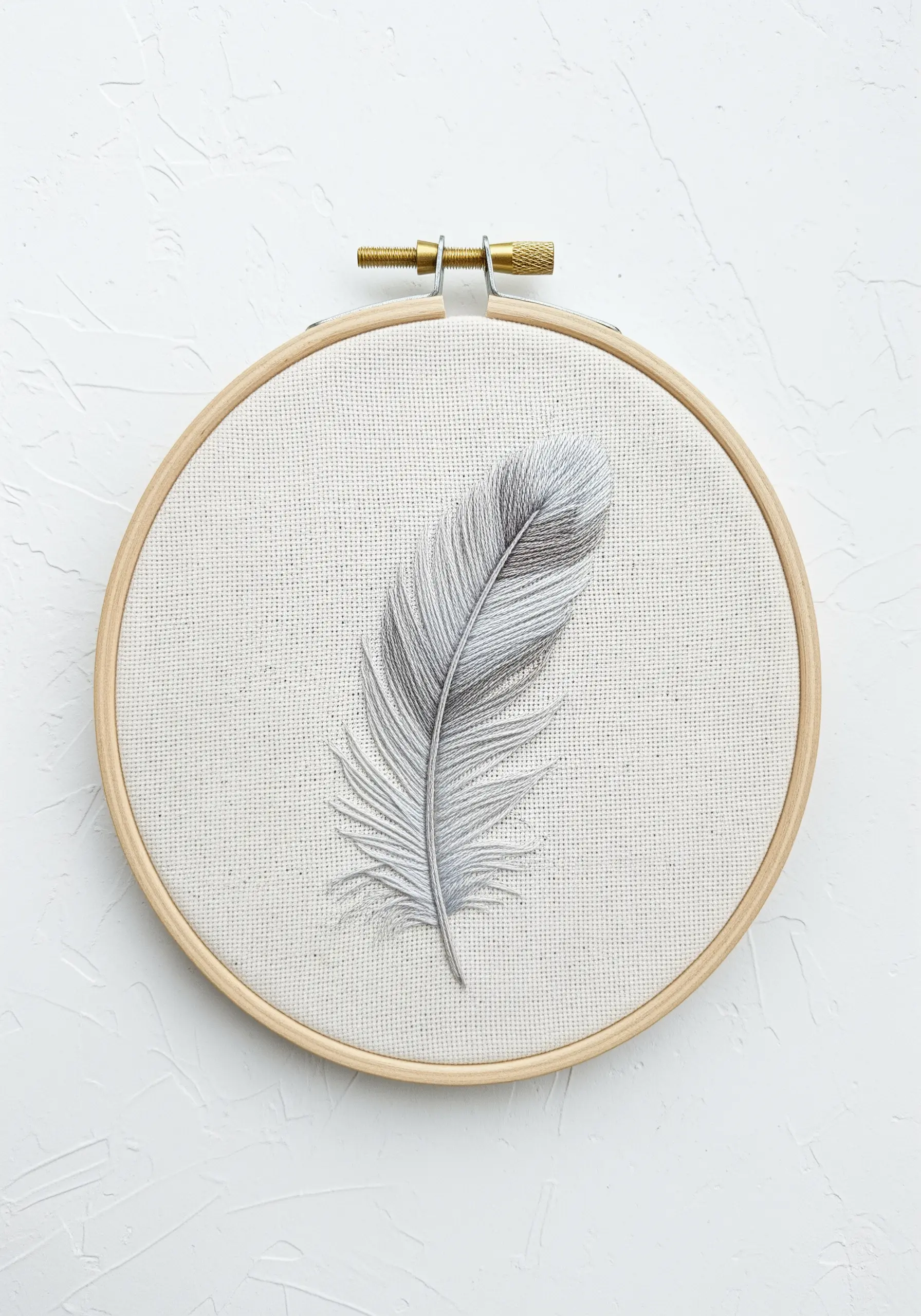 A realistic gray feather created with detailed thread painting.