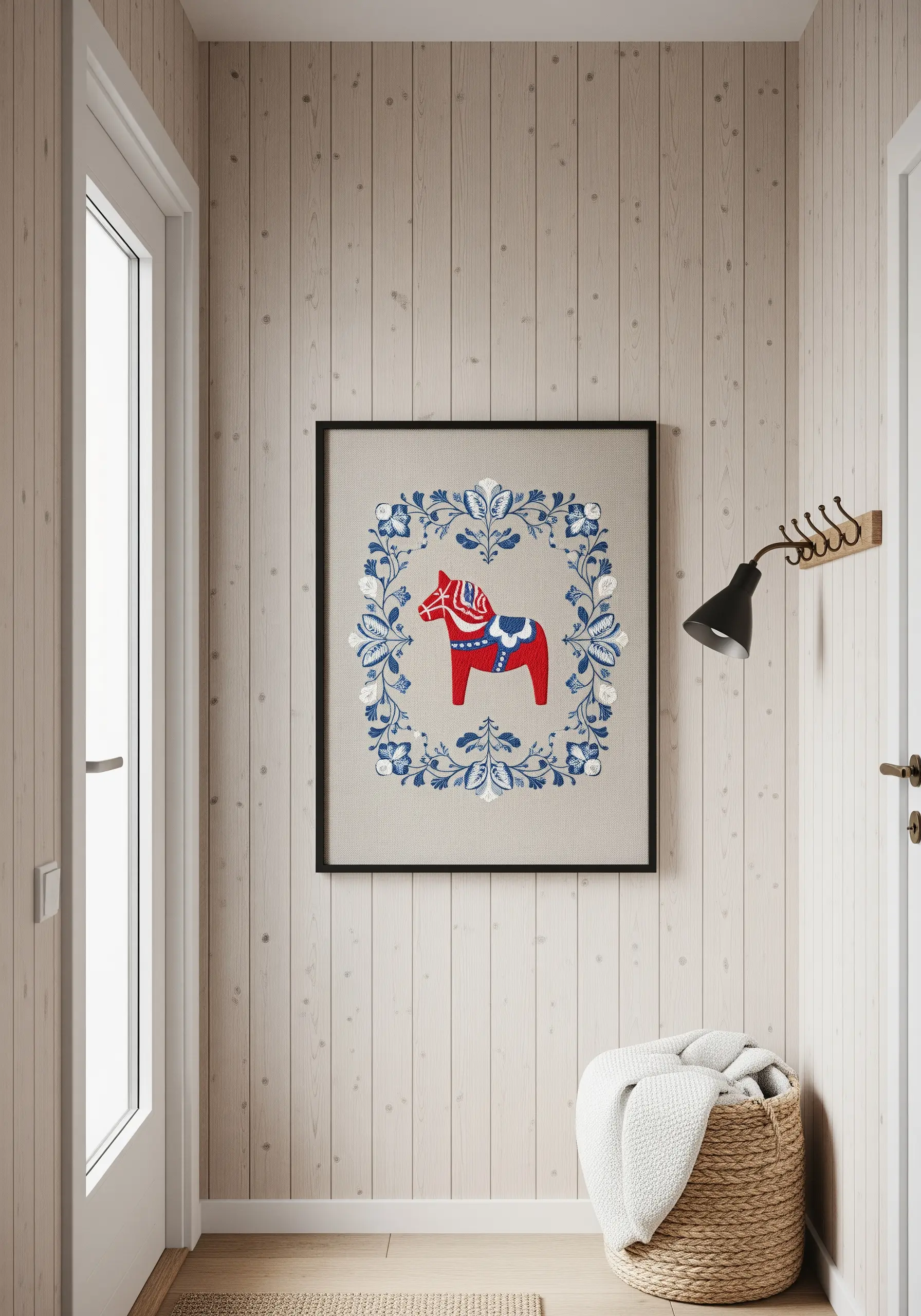 A framed embroidery of a red Swedish Dala horse surrounded by a blue and white floral border.