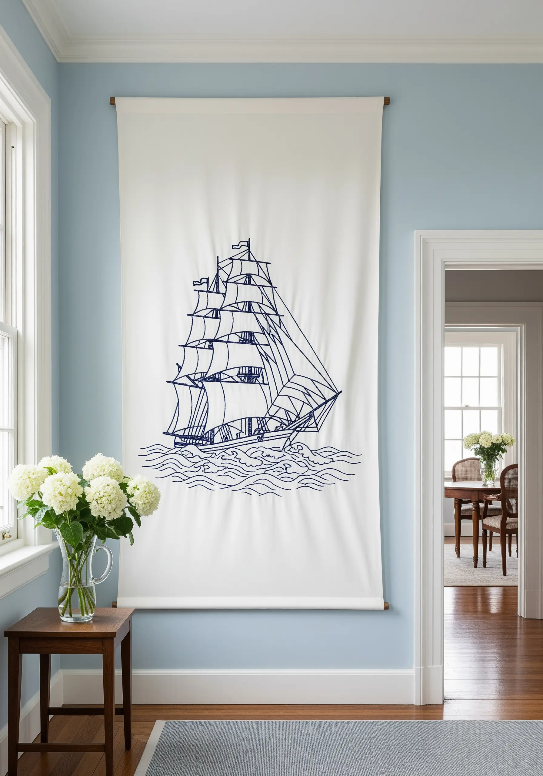 A minimalist line art embroidery of a tall ship on a large white cotton banner.