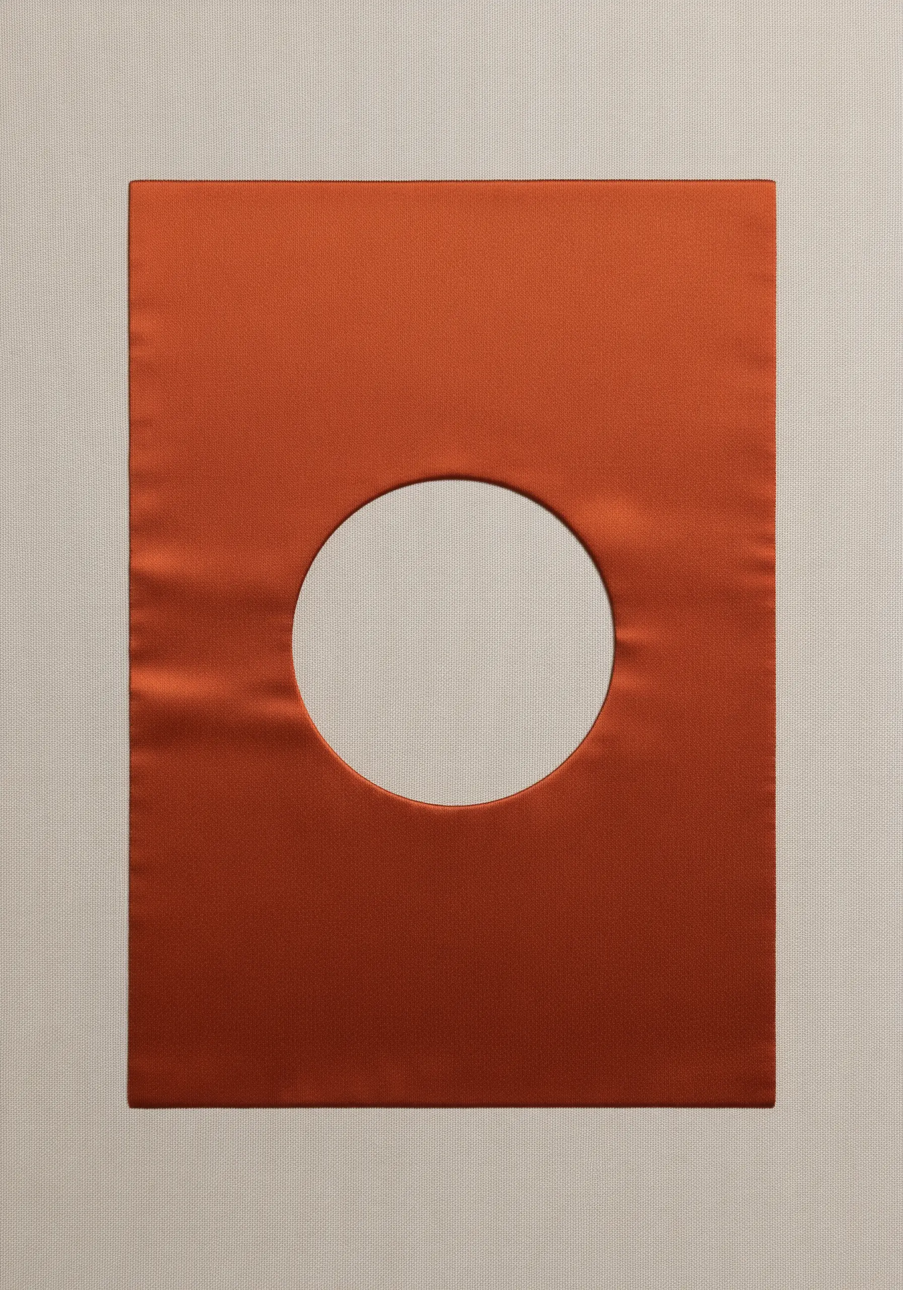 A perfect circle cut from burnt-orange satin reveals the white canvas beneath.