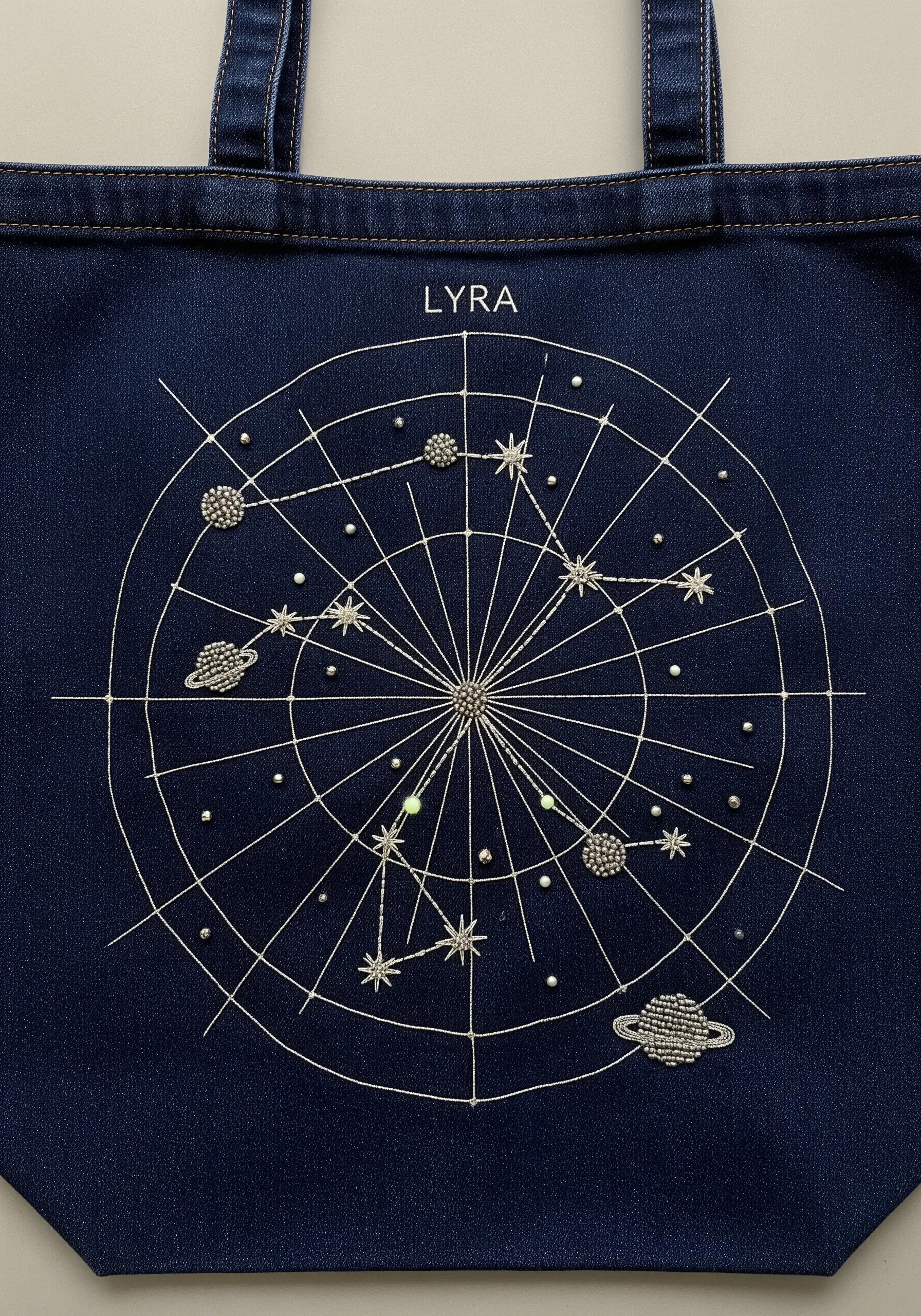A constellation map embroidered on a denim tote bag, with beads representing stars and planets.