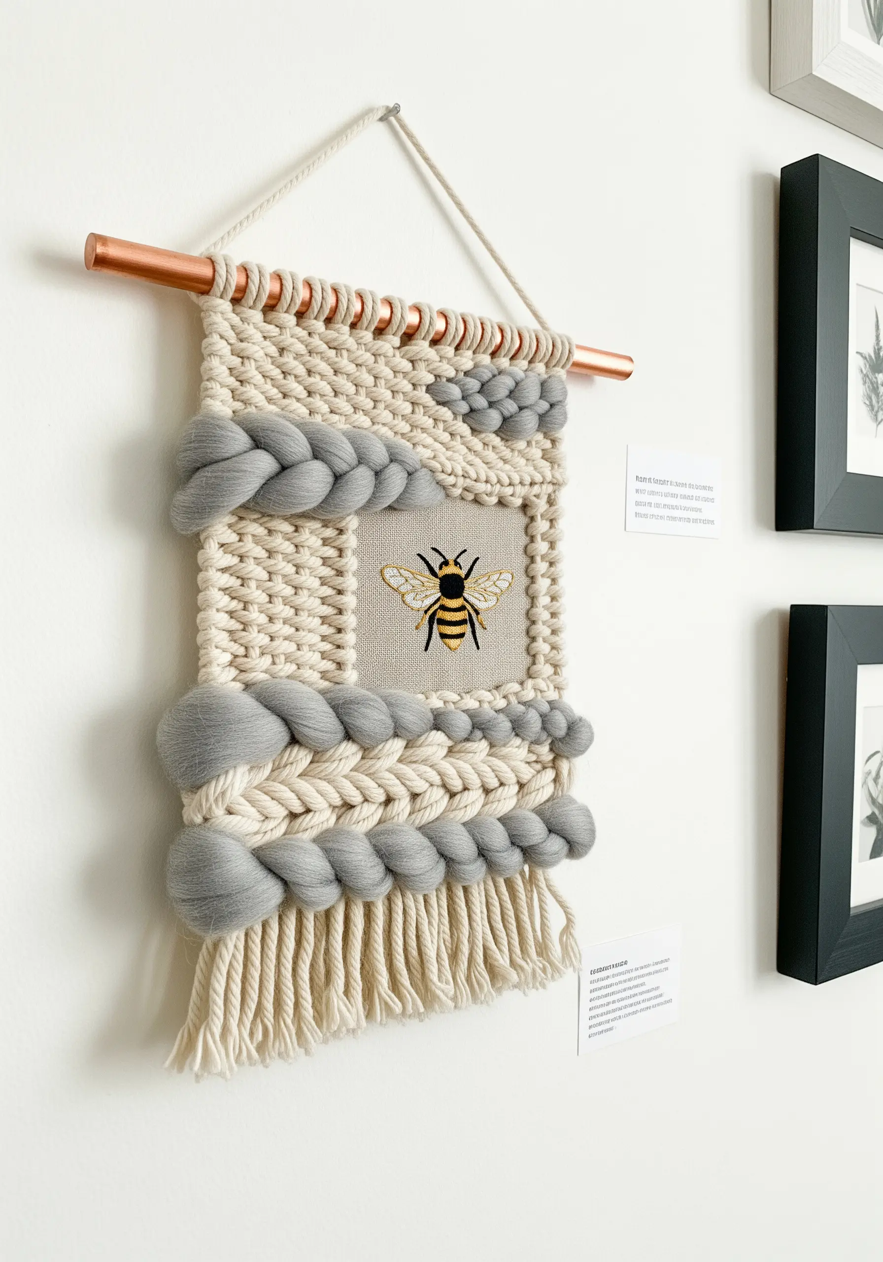 Woven wall hanging with chunky braids framing a central embroidered bee.