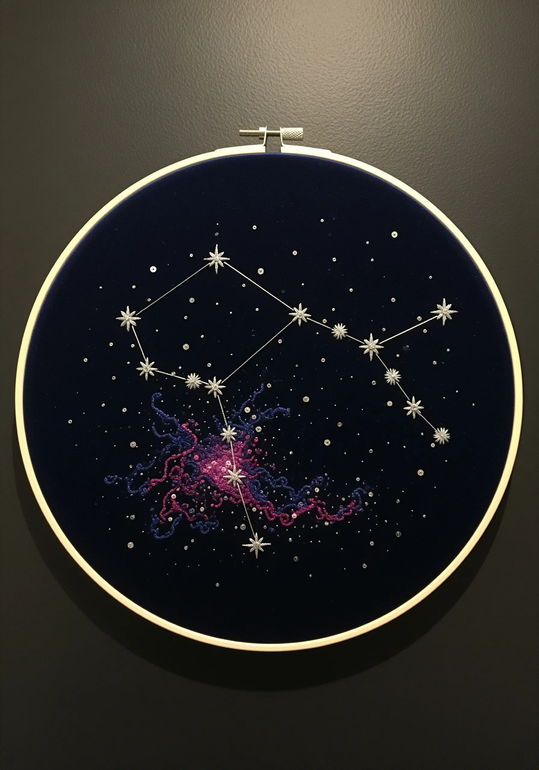 Embroidery of a constellation and nebula on dark blue velvet using beads and metallic thread.