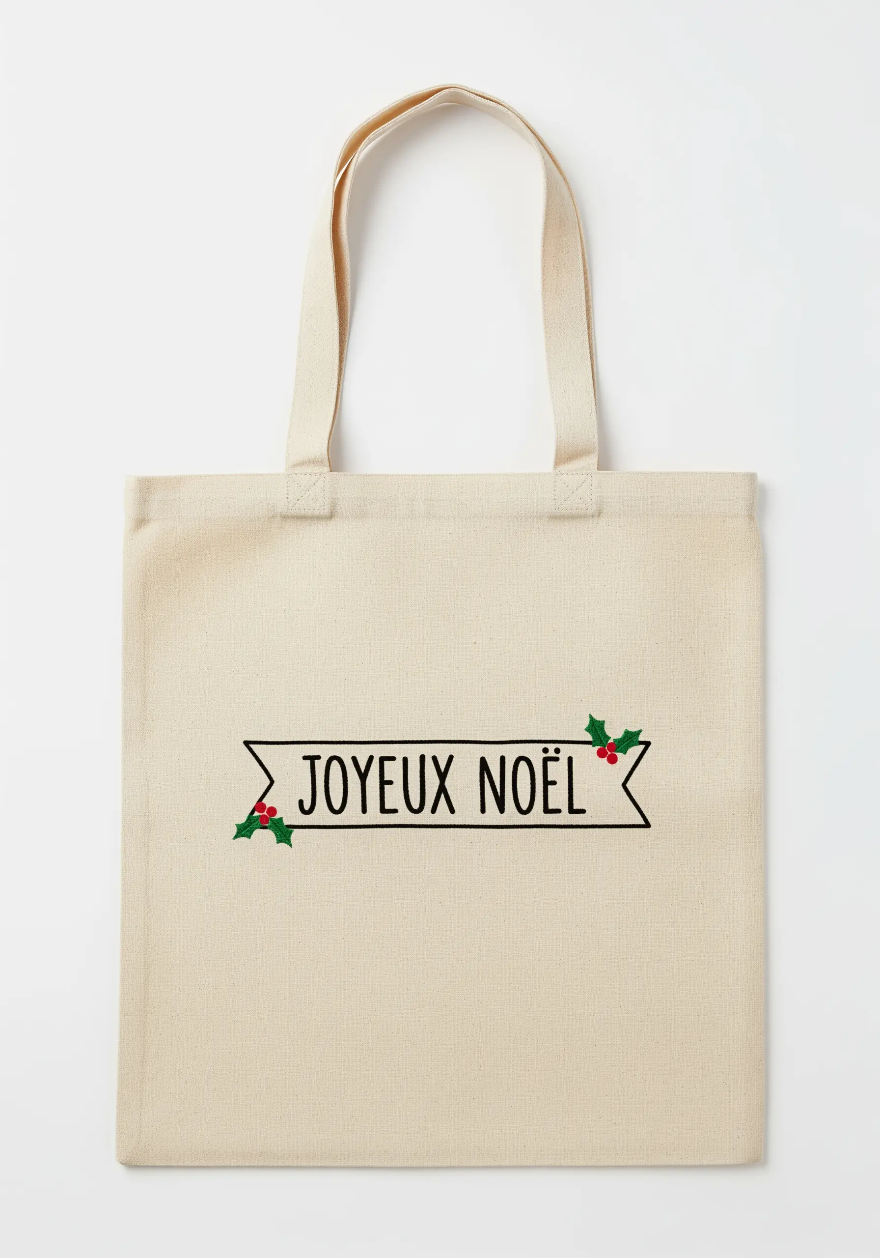 A minimalist black banner with 'Joyeux Noël' and tiny holly accents on a cream canvas tote.