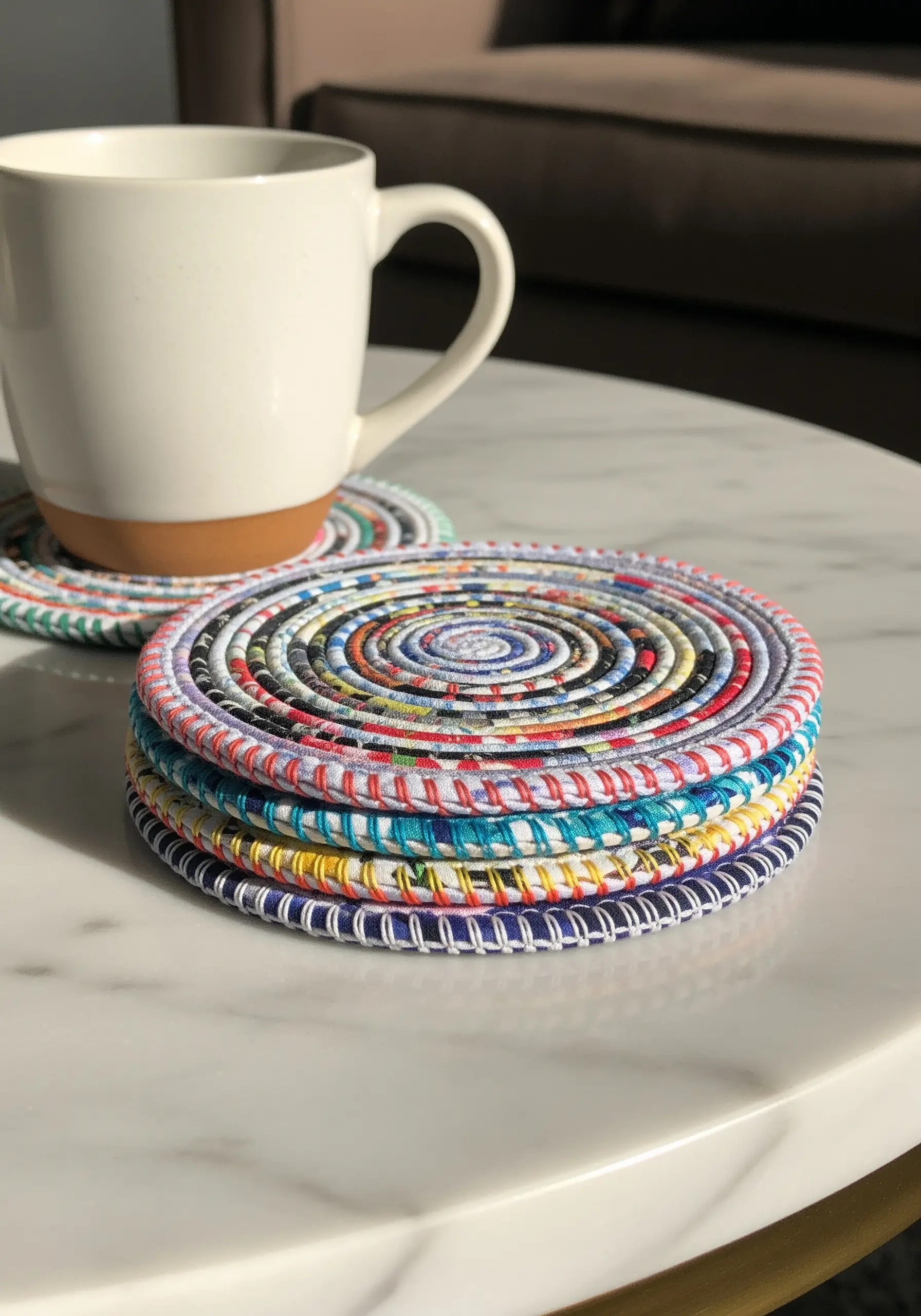 A stack of colorful coasters made from coiled strips of paper stitched together.