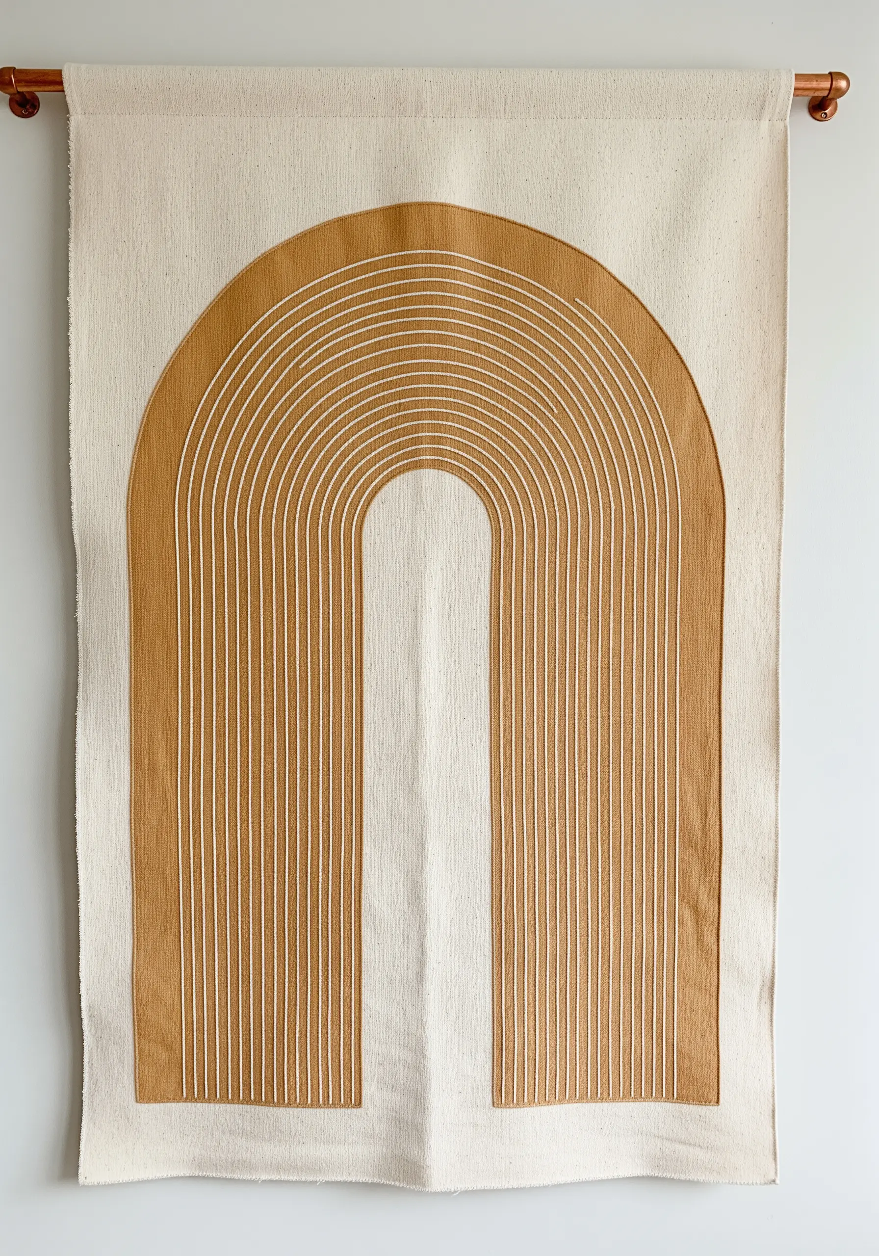 A large wall hanging with a mustard-colored fabric arch appliquéd and stitched with white lines.