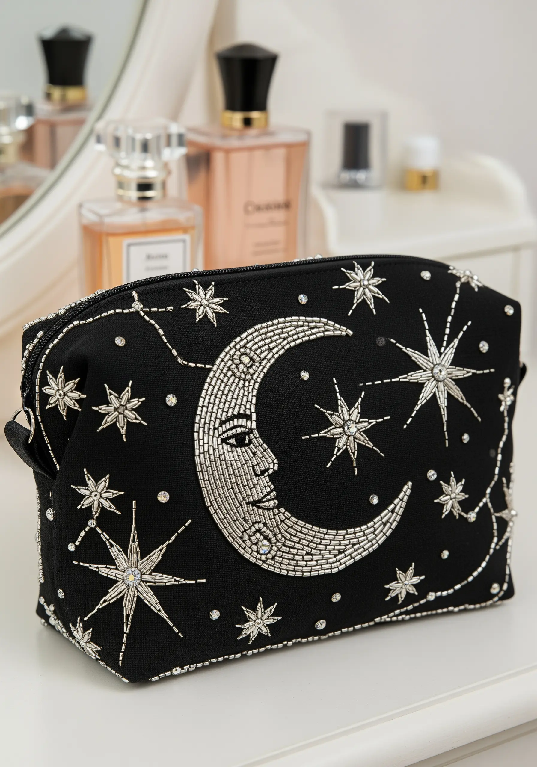 Black makeup bag embellished with a silver-beaded moon and metallic thread stars.