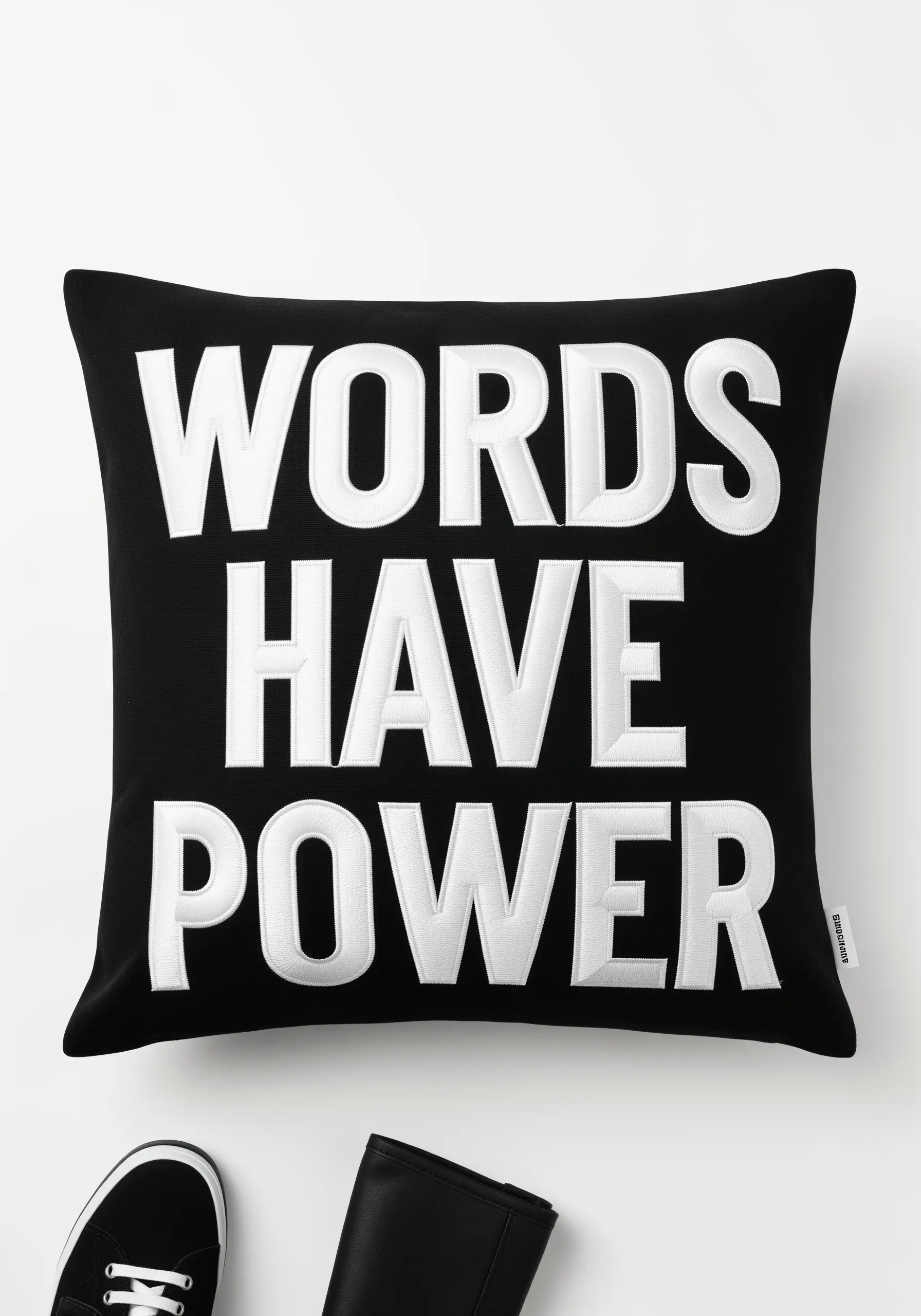 Extremely raised, high-relief white satin stitch lettering on a black pillow.