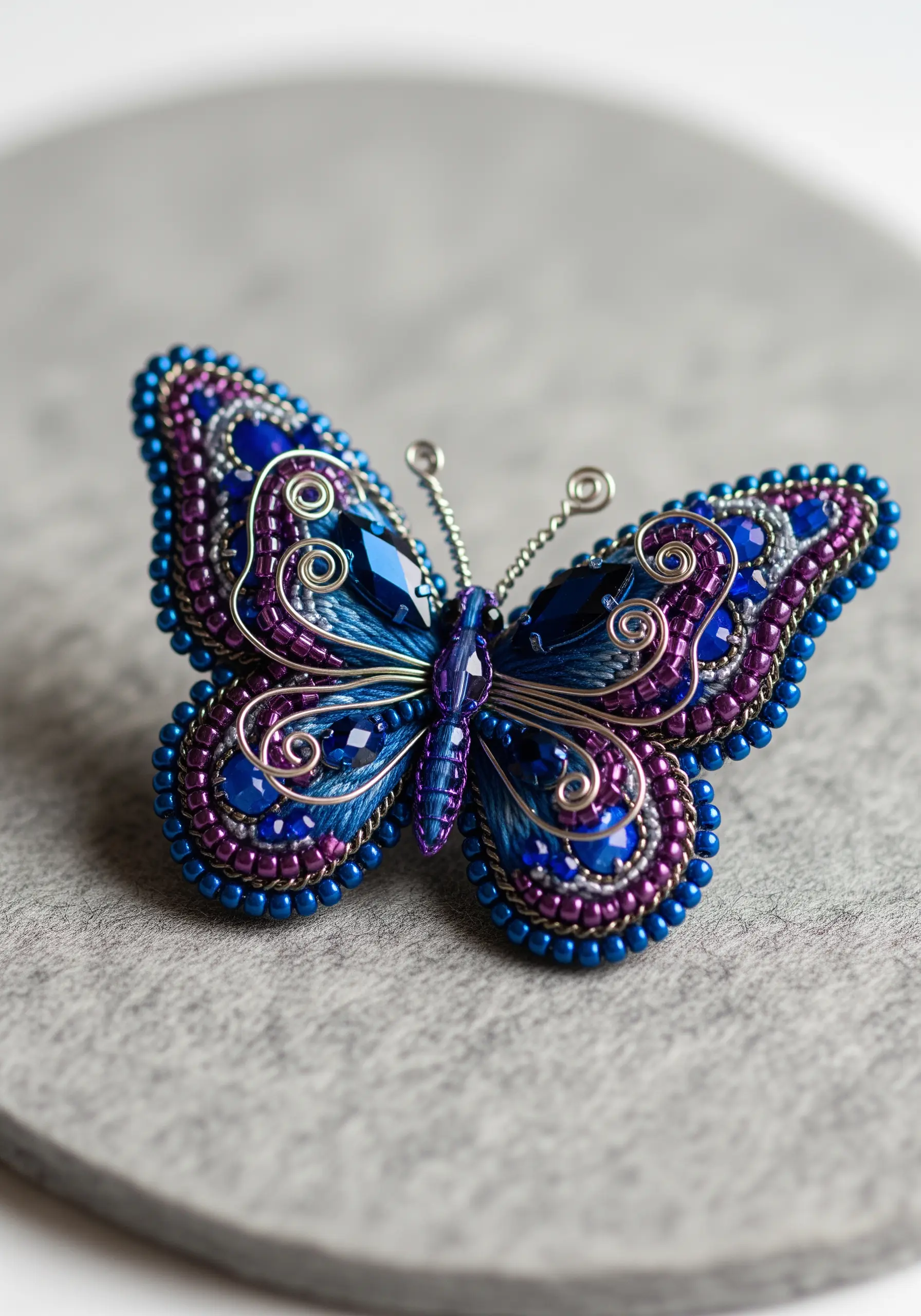 Intricate 3D butterfly brooch made with blue and purple beads and wire.