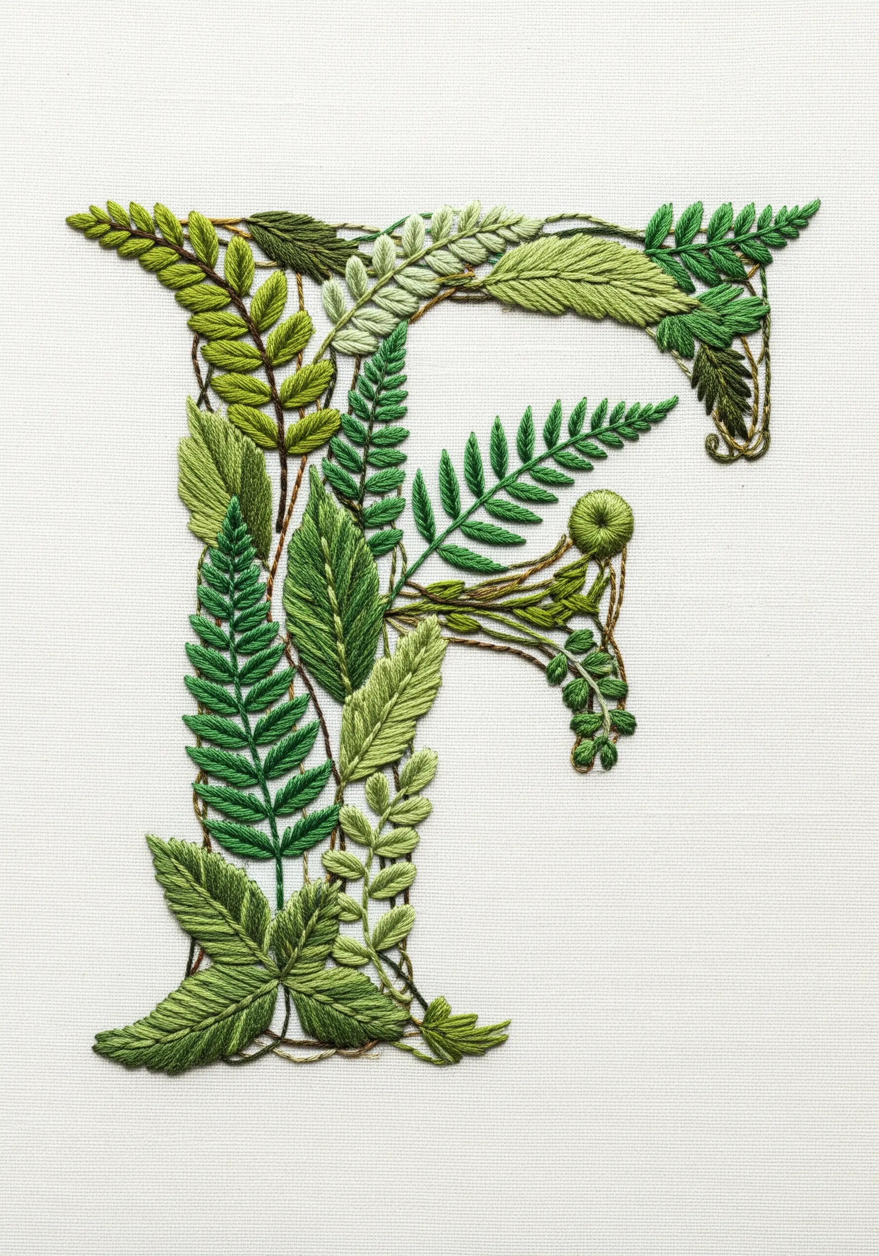 The letter 'F' formed from a variety of intricately embroidered green leaves and ferns.