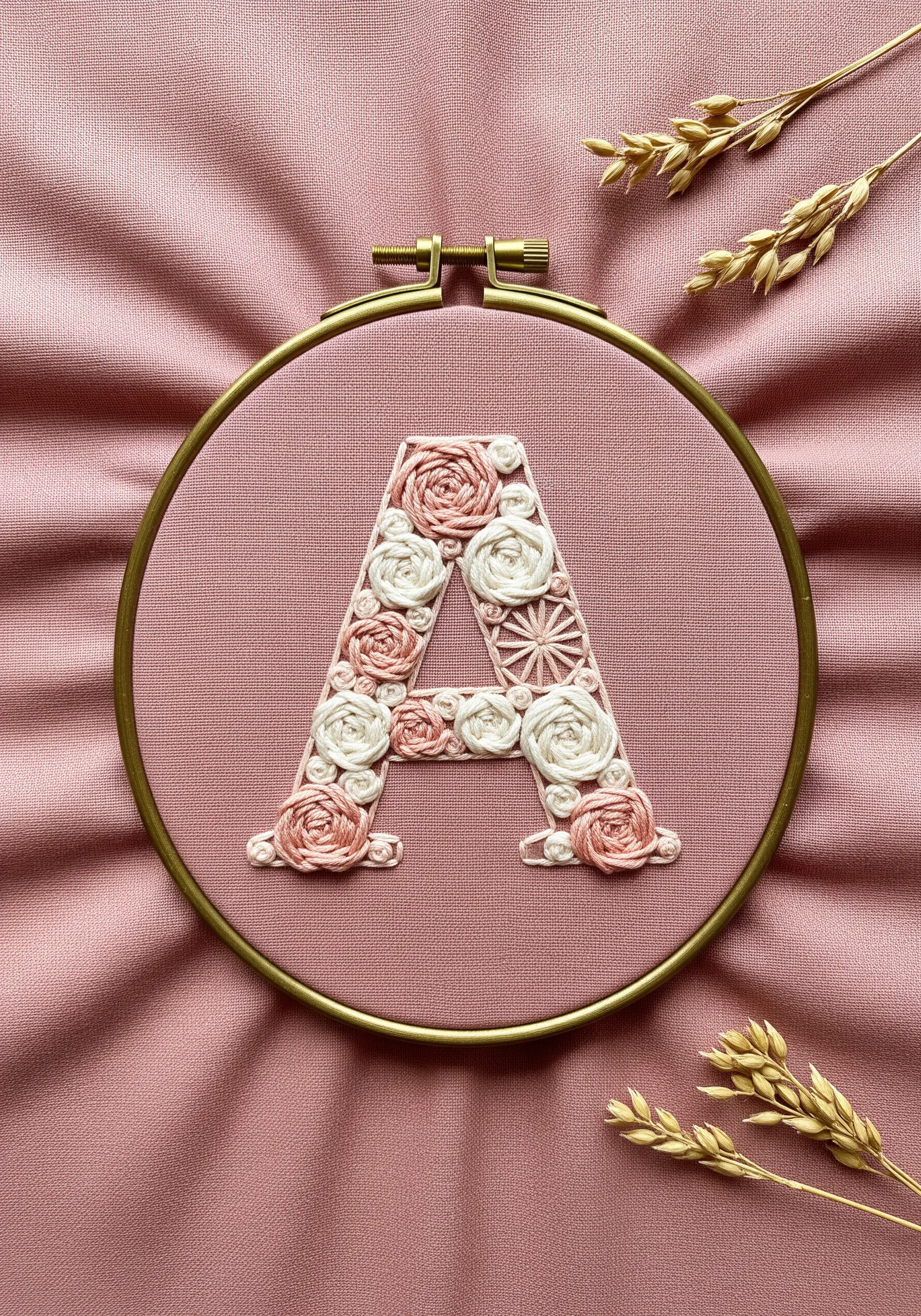 Monogram letter 'A' filled with pink and white woven wheel roses and French knots.