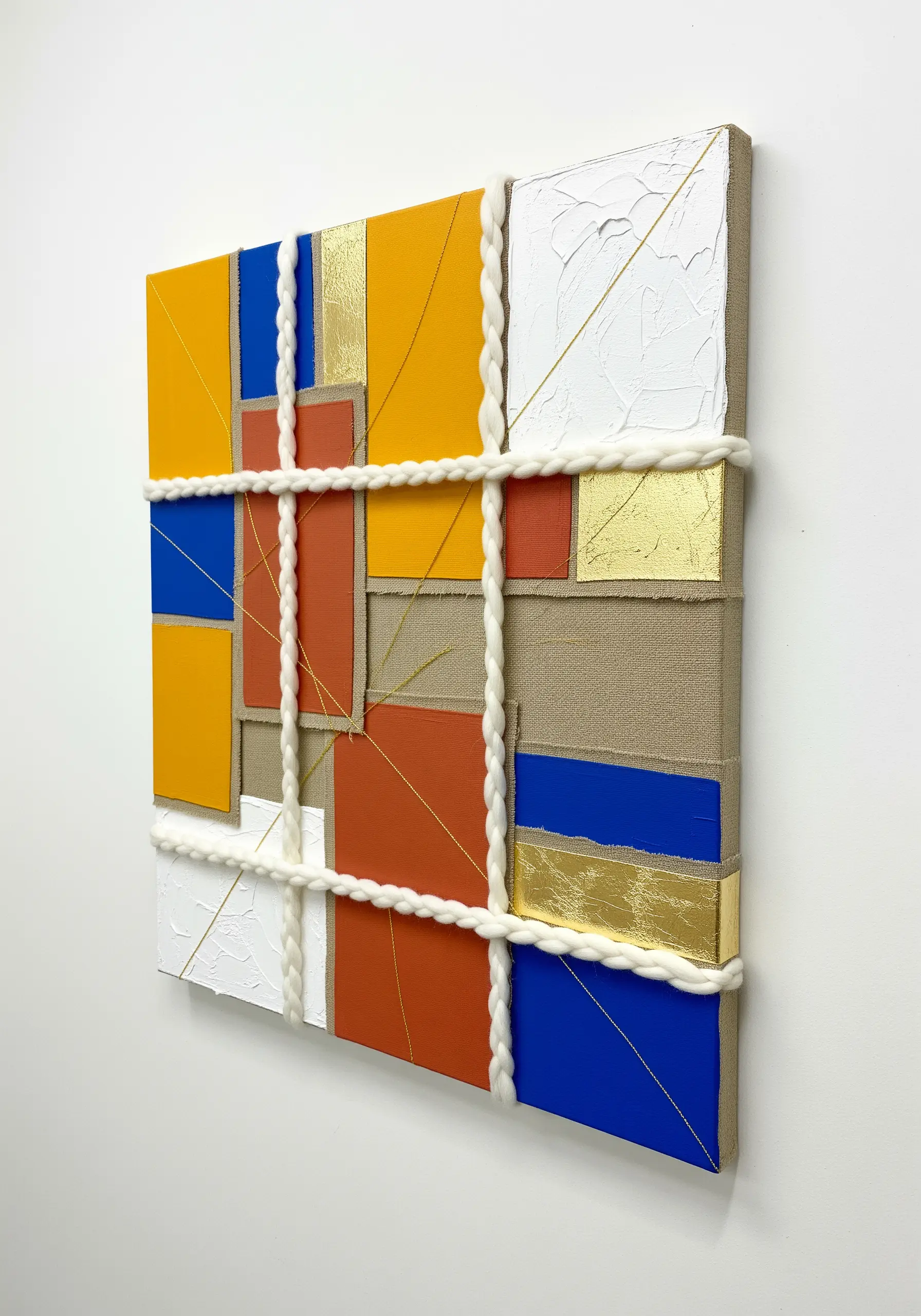 Abstract geometric art with painted blocks, gold leaf, and a grid of thick white cord.
