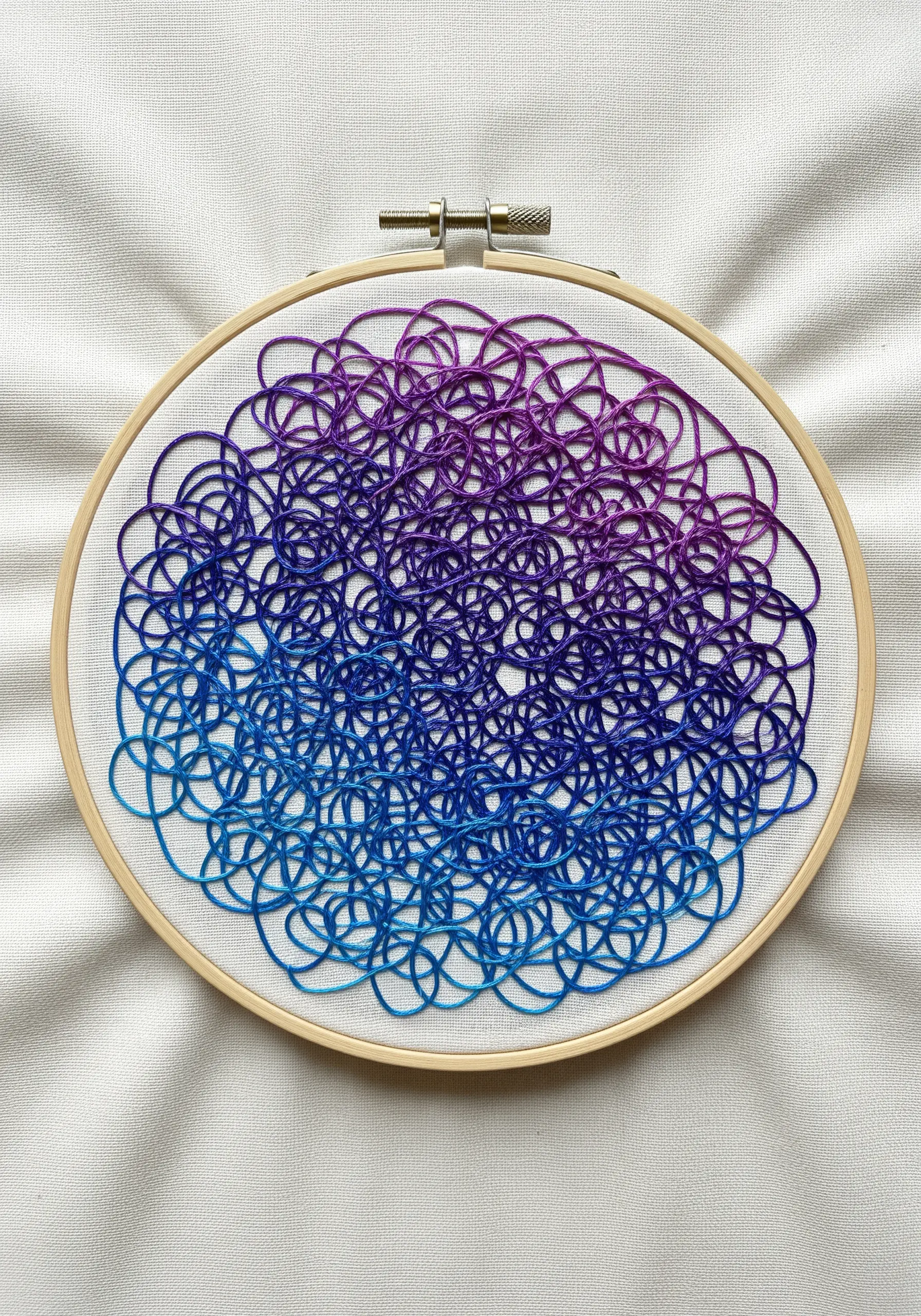 A dense tangle of looped threads transitioning from blue to purple.