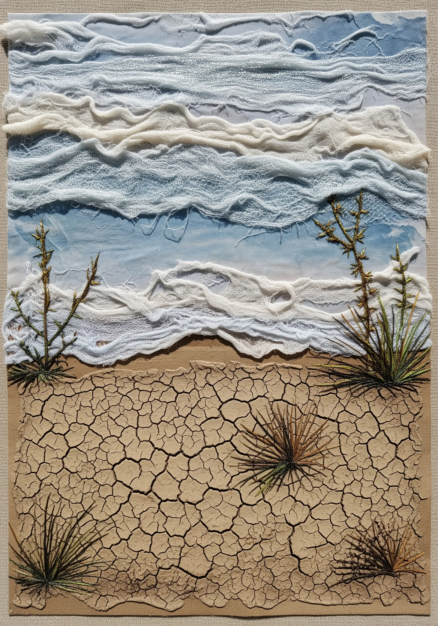A desert landscape collage with crackle paste for the ground and gauze for clouds.