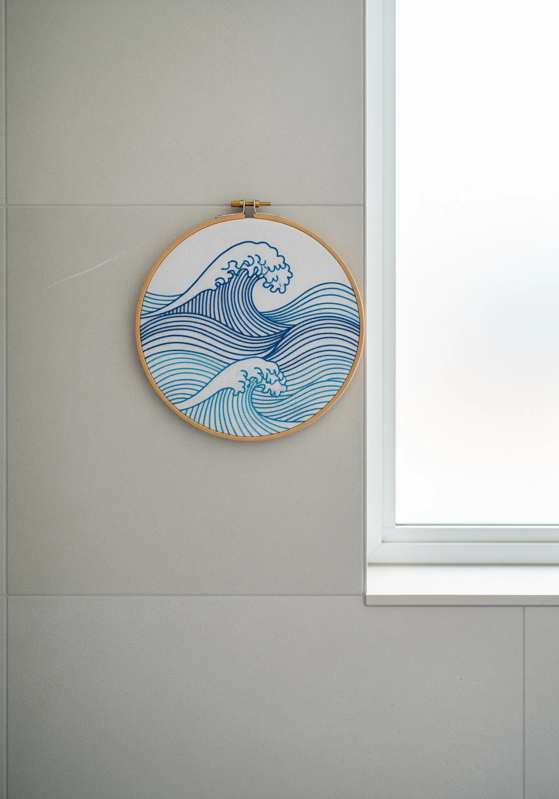 Embroidery of stylized ocean waves in multiple shades of blue thread.