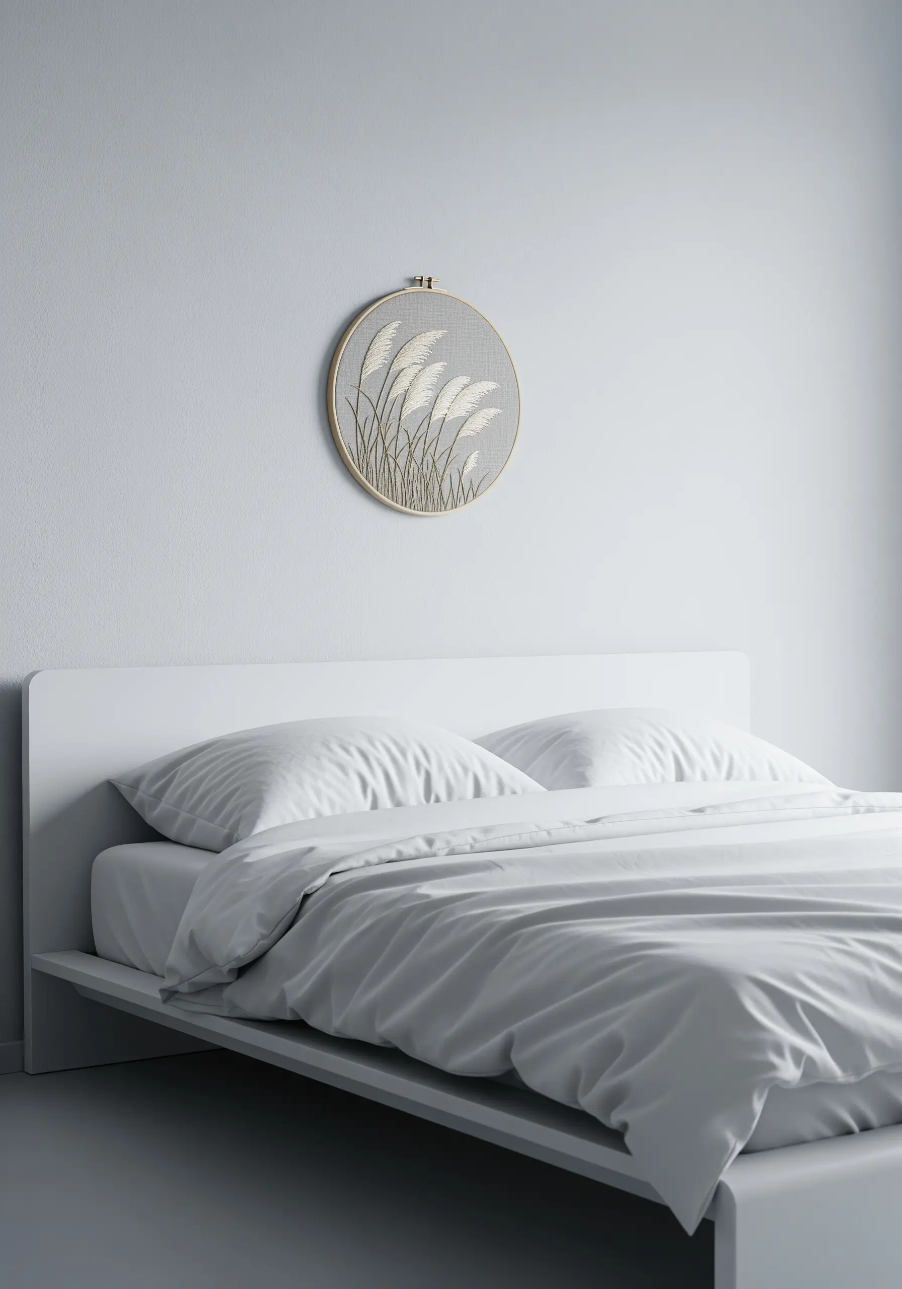 Minimalist embroidery of white pampas grass on a textured grey fabric.