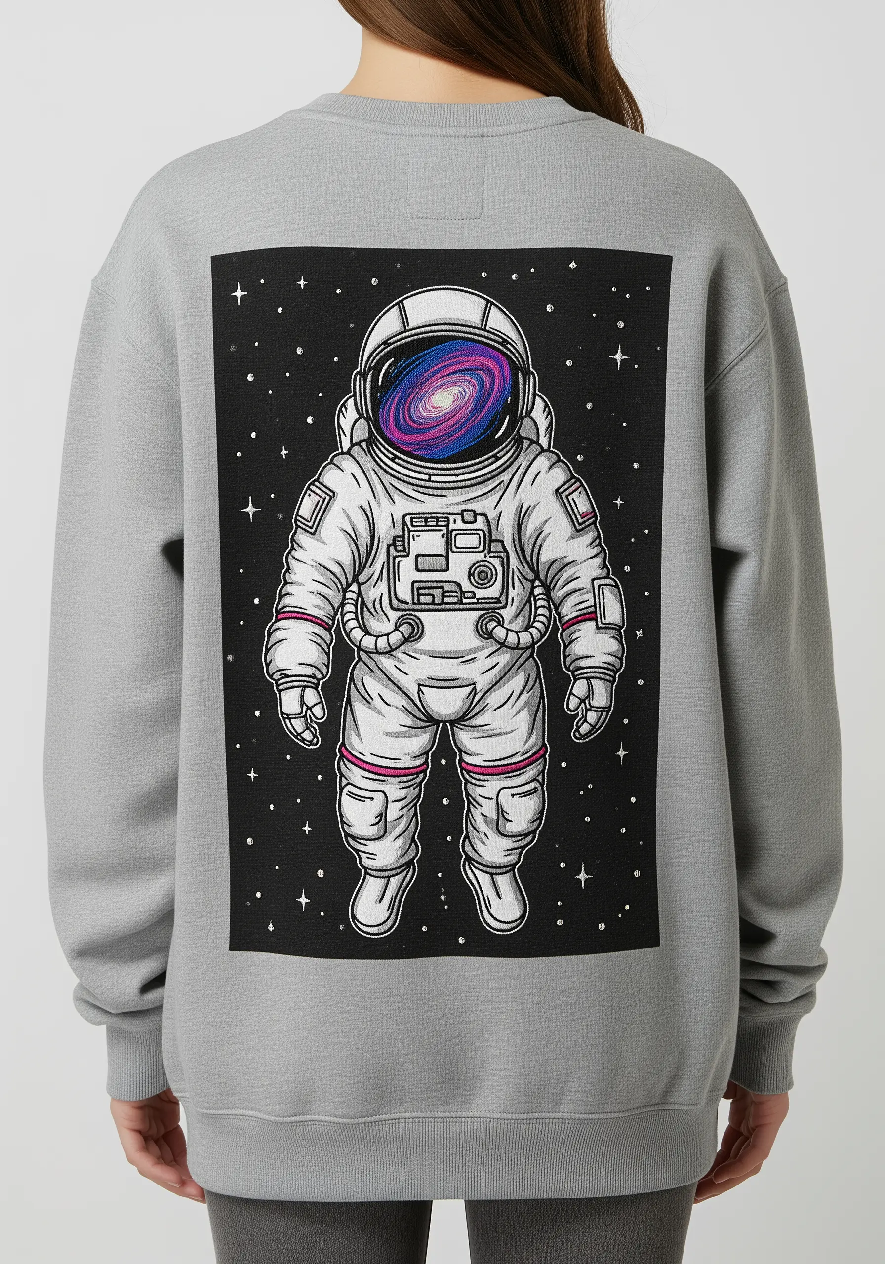 An astronaut with a swirling galaxy reflected in their helmet, embroidered on a grey sweatshirt.