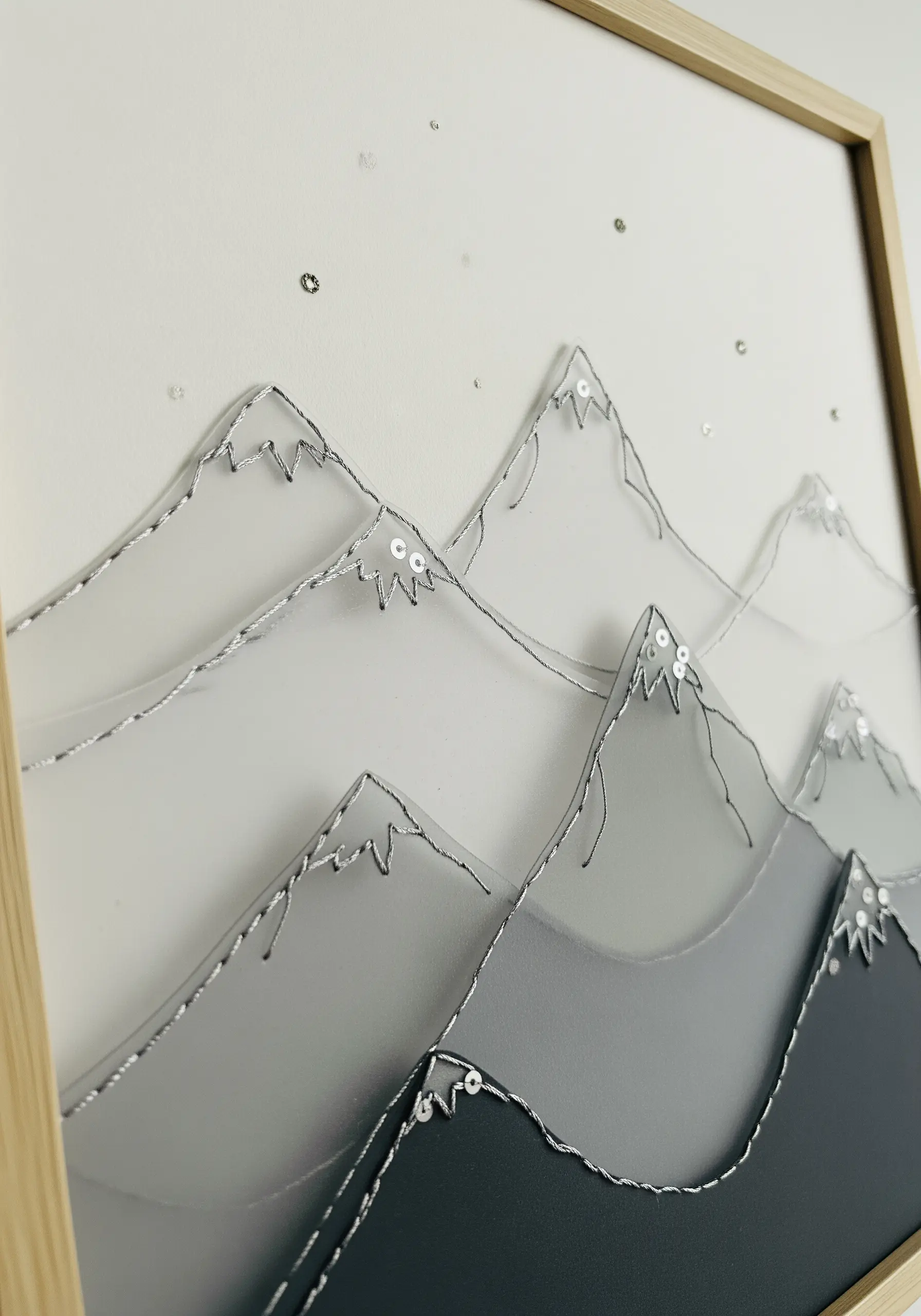 Layered vellum mountains outlined with silver thread and sequins for a frosty effect.
