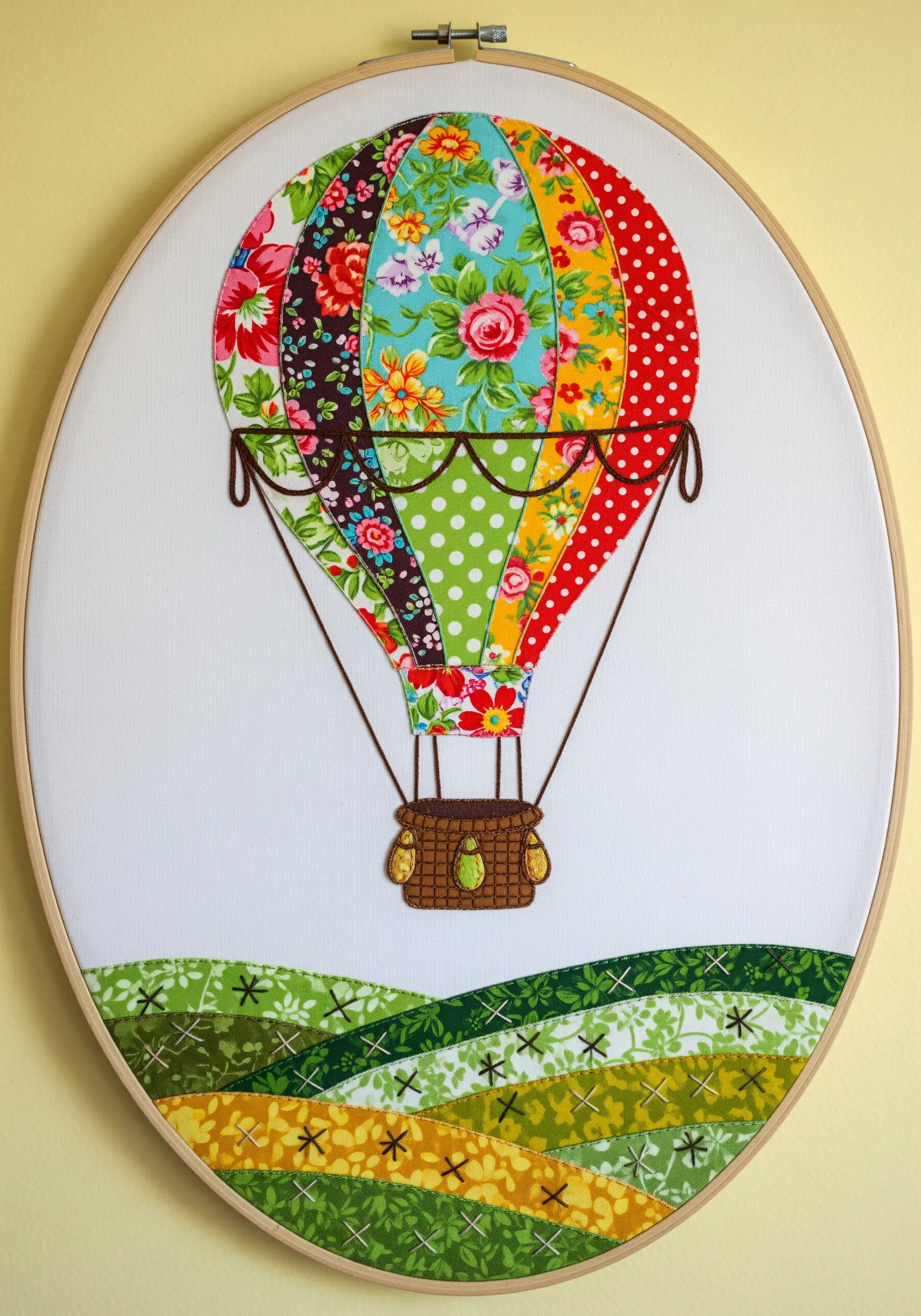 Hot air balloon made from colorful patchwork fabric scraps with embroidered details.