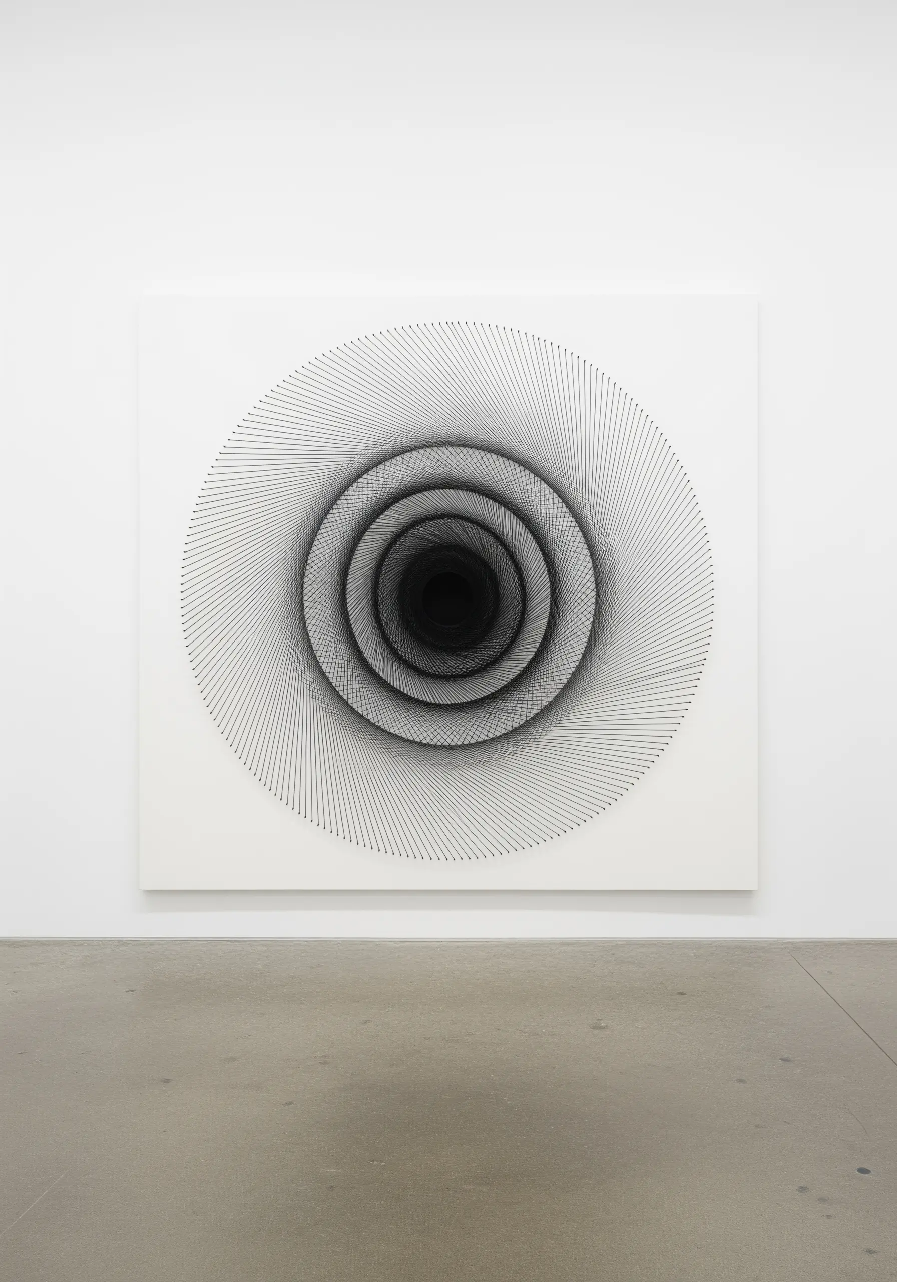 A large-scale string art spiral creating a black and white optical illusion of a vortex.