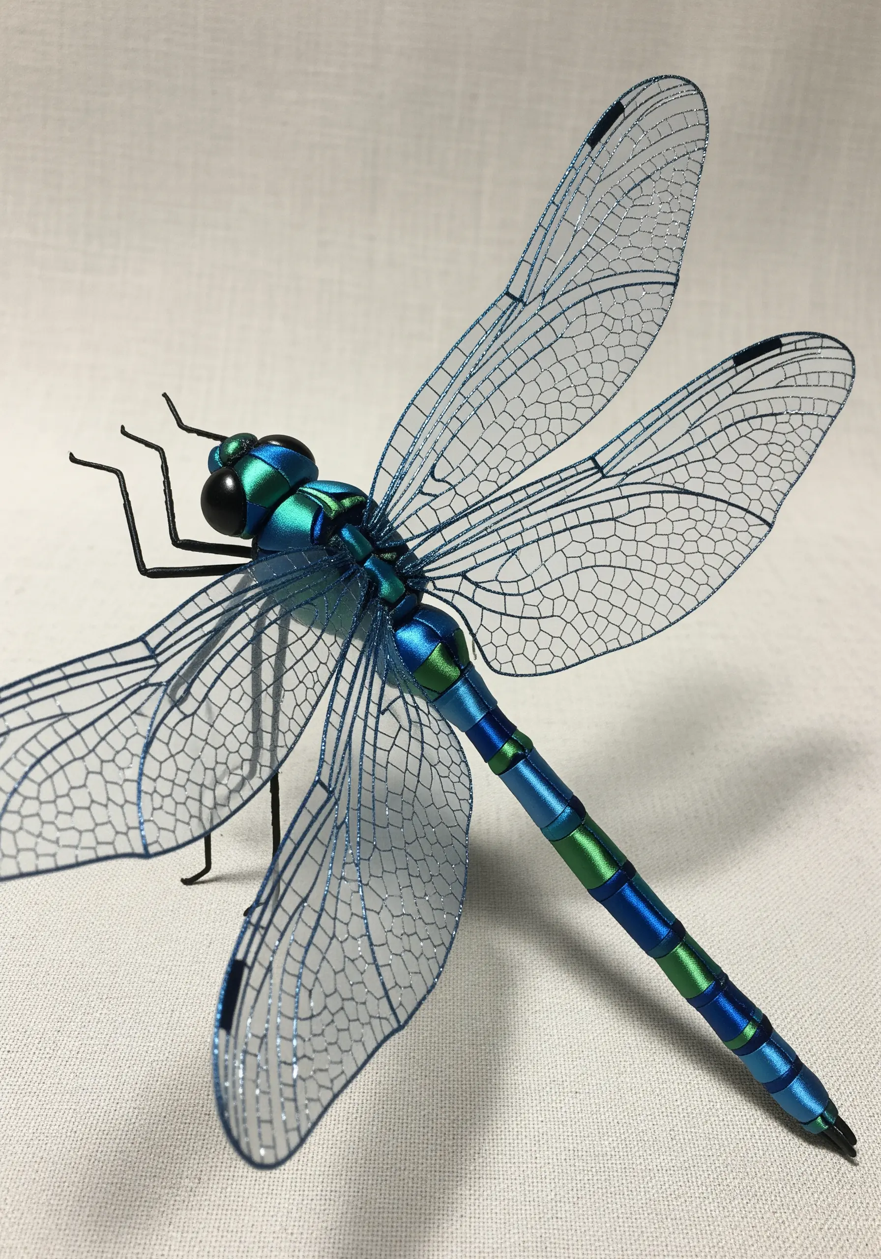 A 3D dragonfly with wings made from embroidered sheer organza over a wire frame.