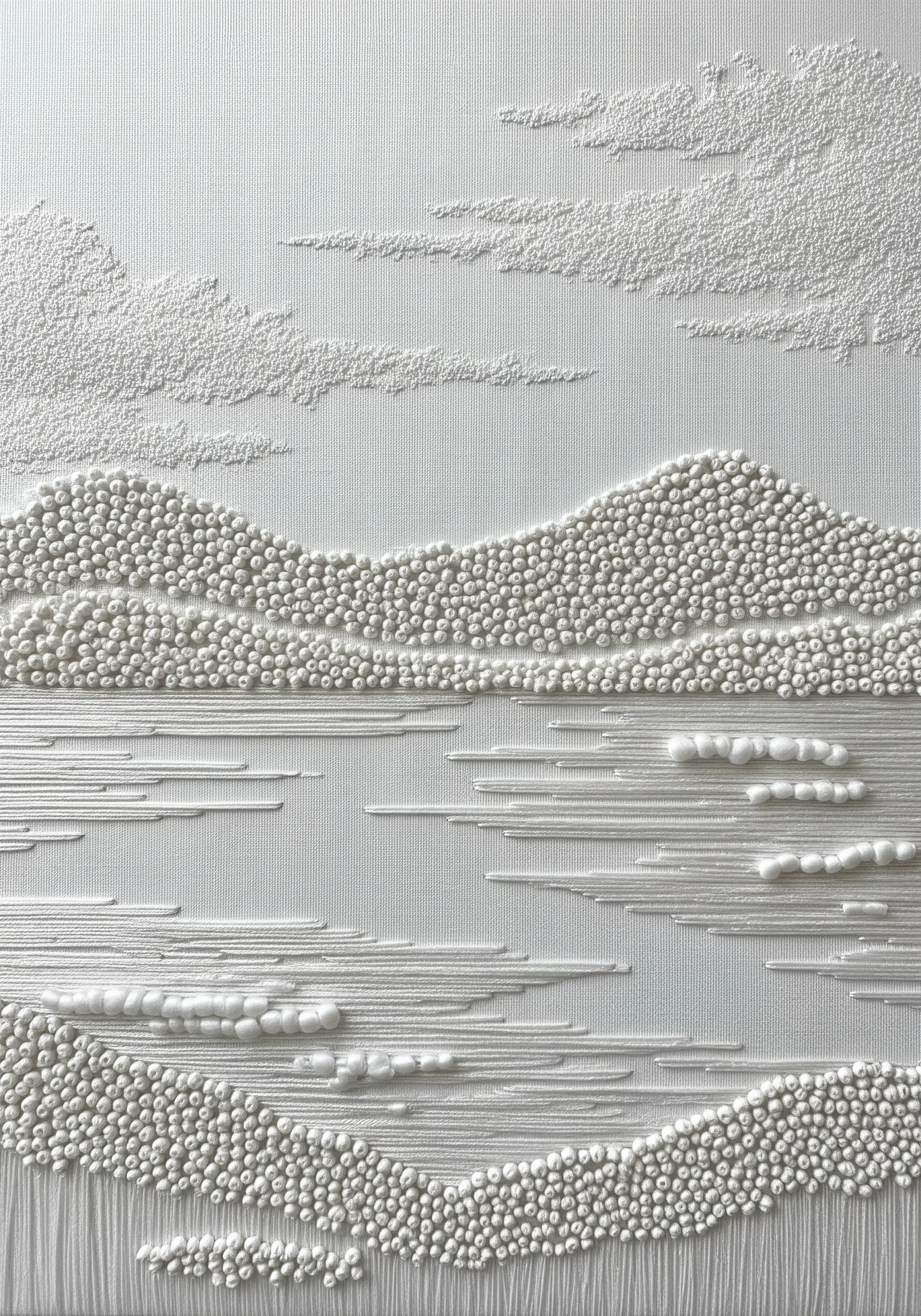A textural white-on-white embroidered landscape using French knots and satin stitches.