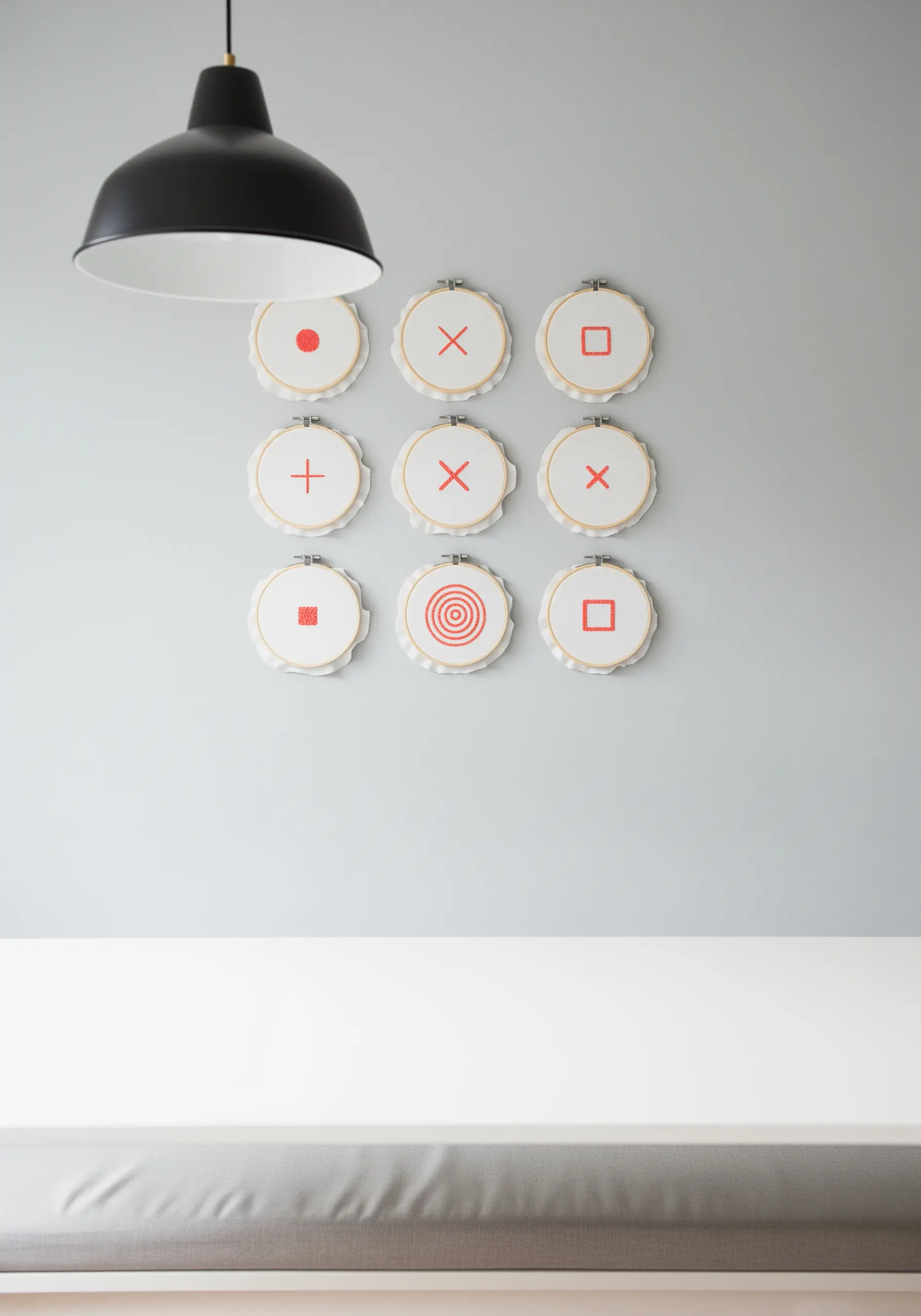 A nine-hoop grid displaying simple red geometric symbols on a grey wall.
