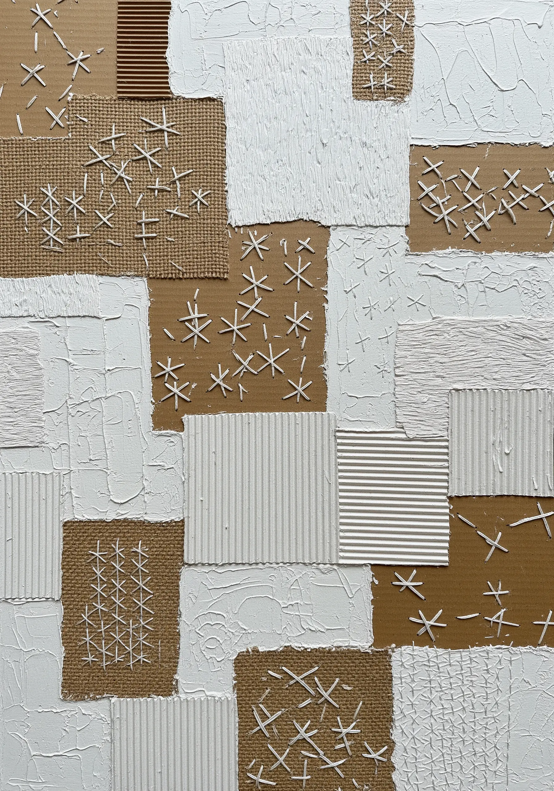 An abstract collage of burlap and cardboard with scattered white seed stitches and cross stitches.