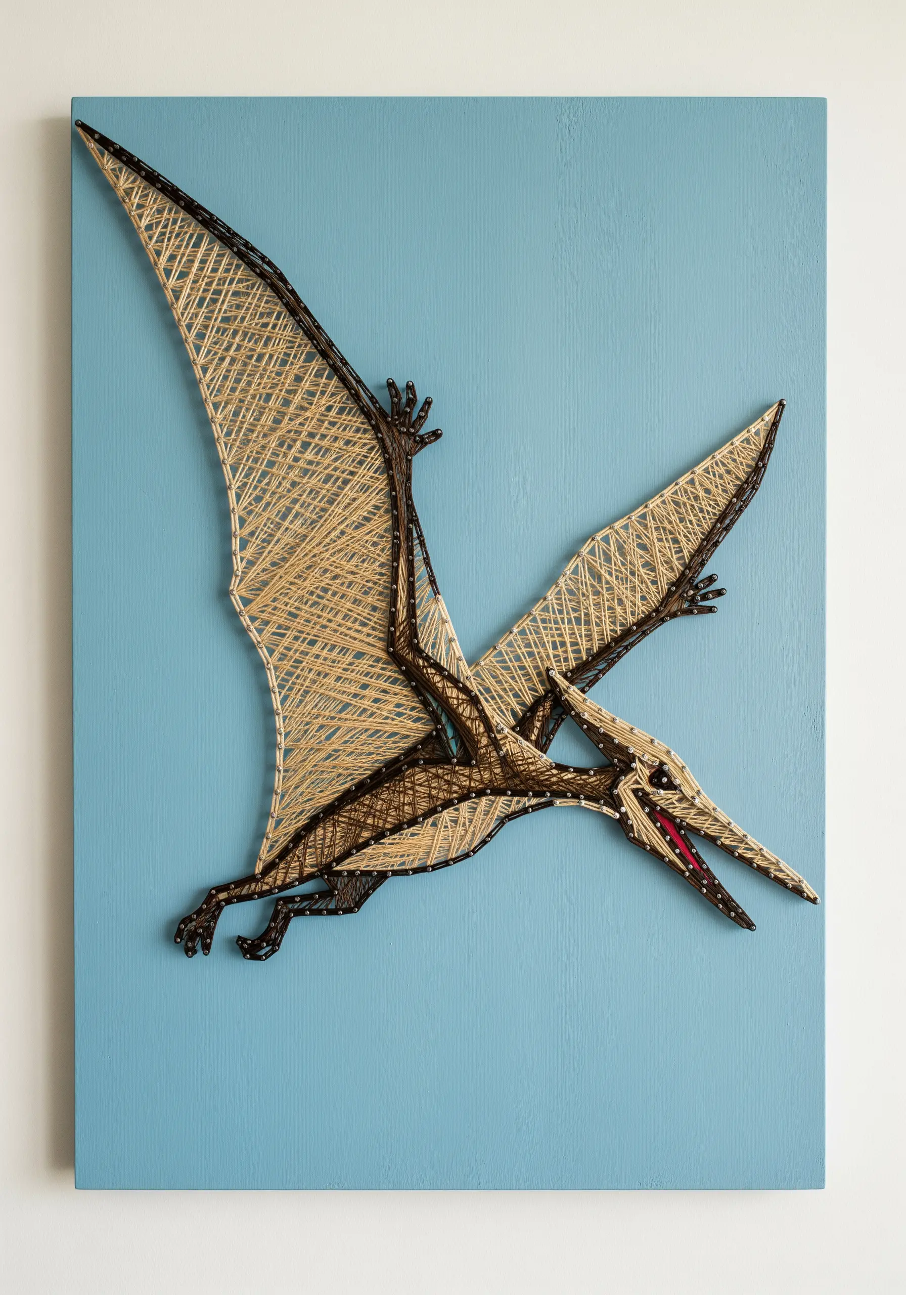 A pterodactyl in flight, embroidered with an open, web-like fill for the wings.
