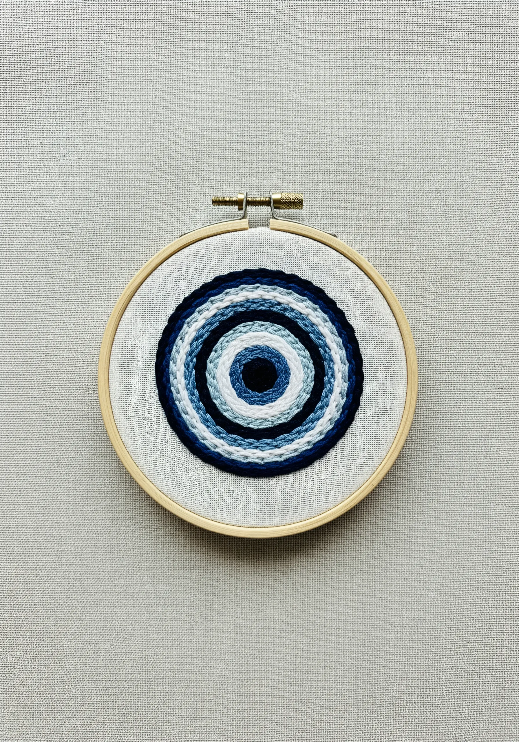 A mandala of concentric circles in shades of blue, white, and black.