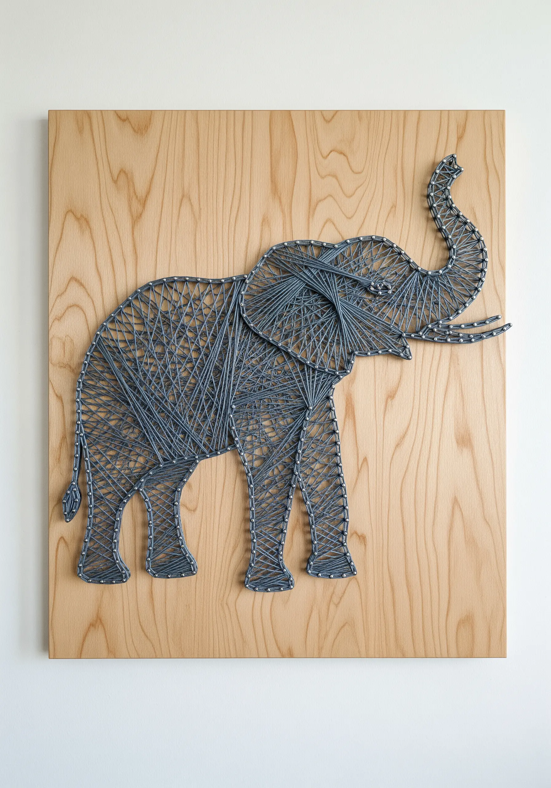 An elephant embroidered with grey thread, using stitch direction to create contour and form.