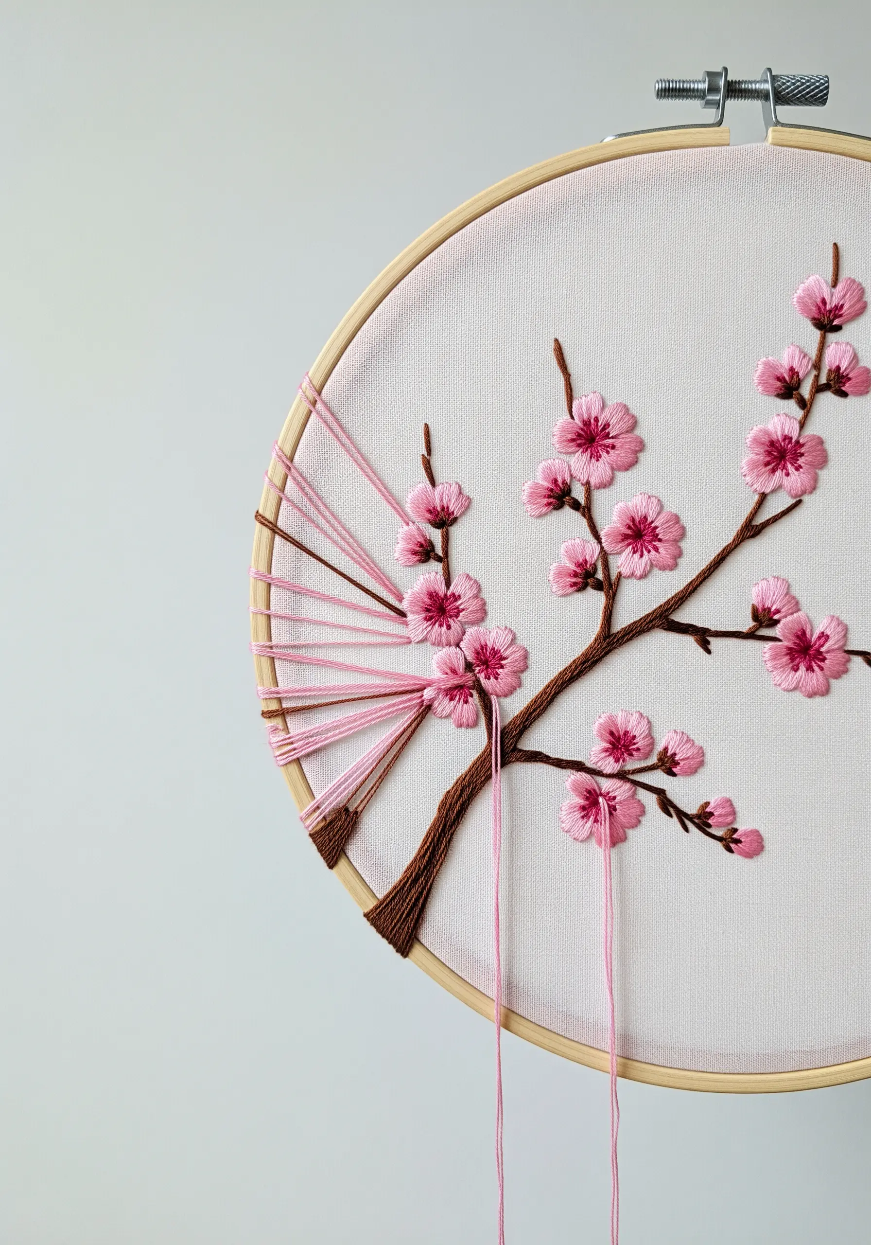 Embroidered cherry blossoms with pink lazy daisy stitches and a modern, deconstructed look.