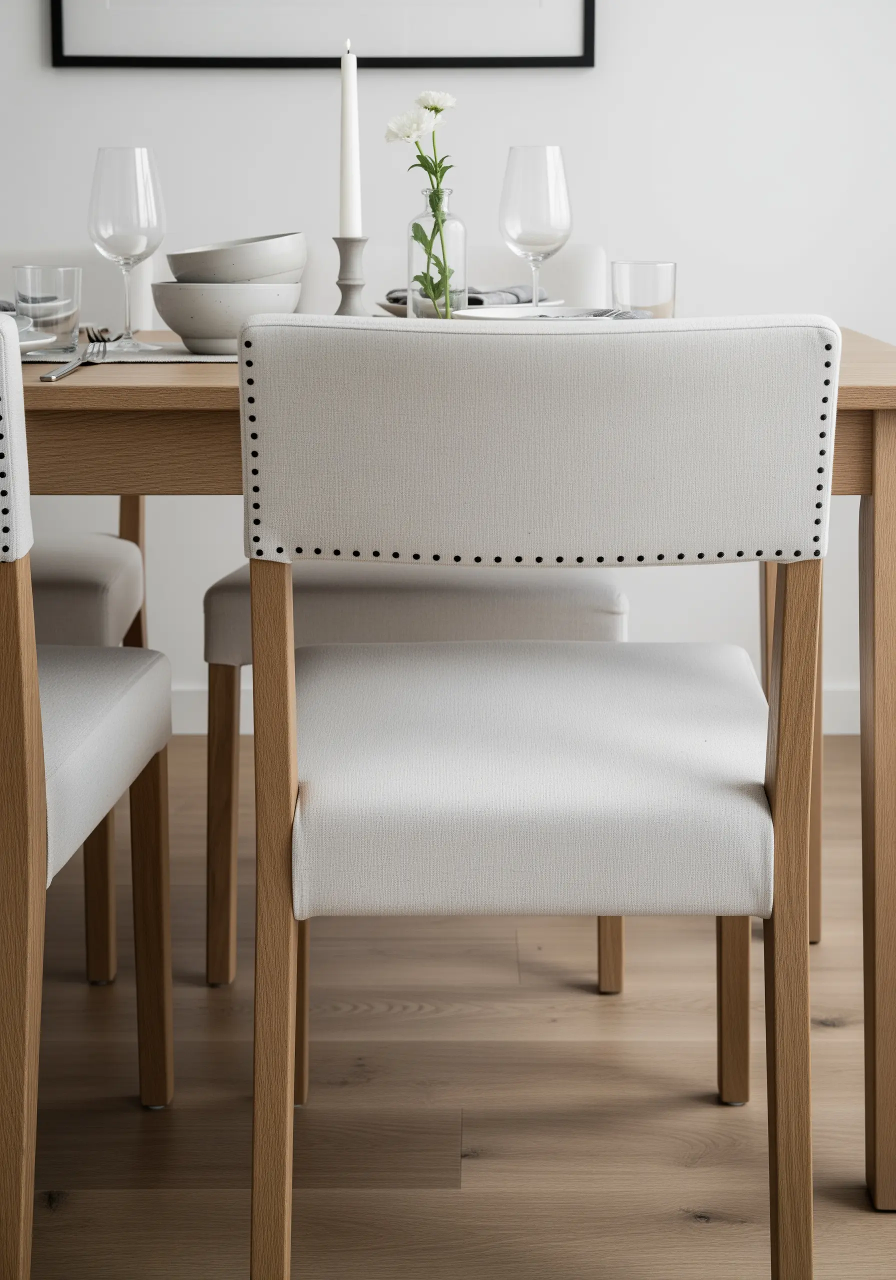 The back of a white dining chair outlined with a border of black French knots.