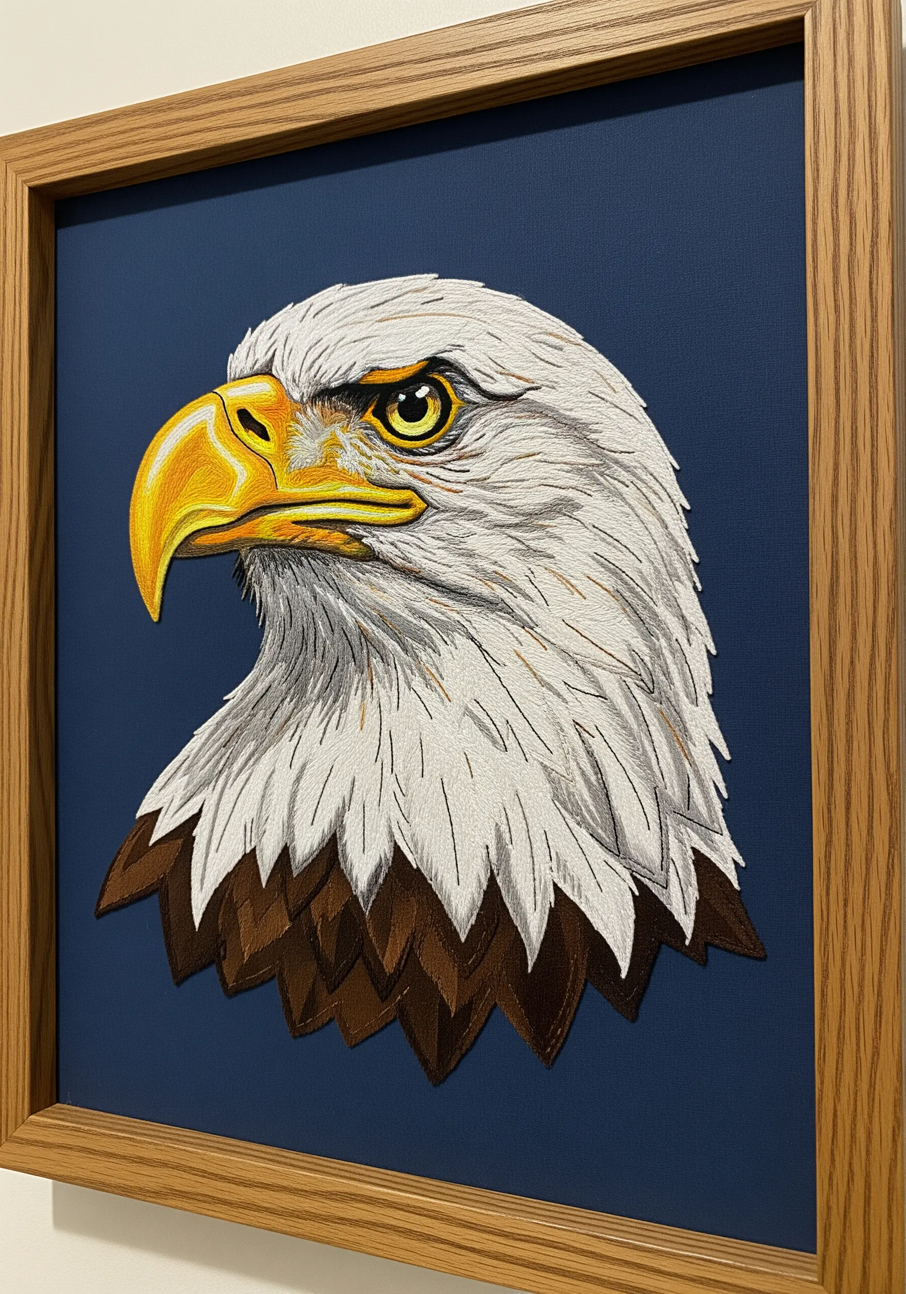 A portrait of a bald eagle with feathers created through carefully layered directional satin stitches.