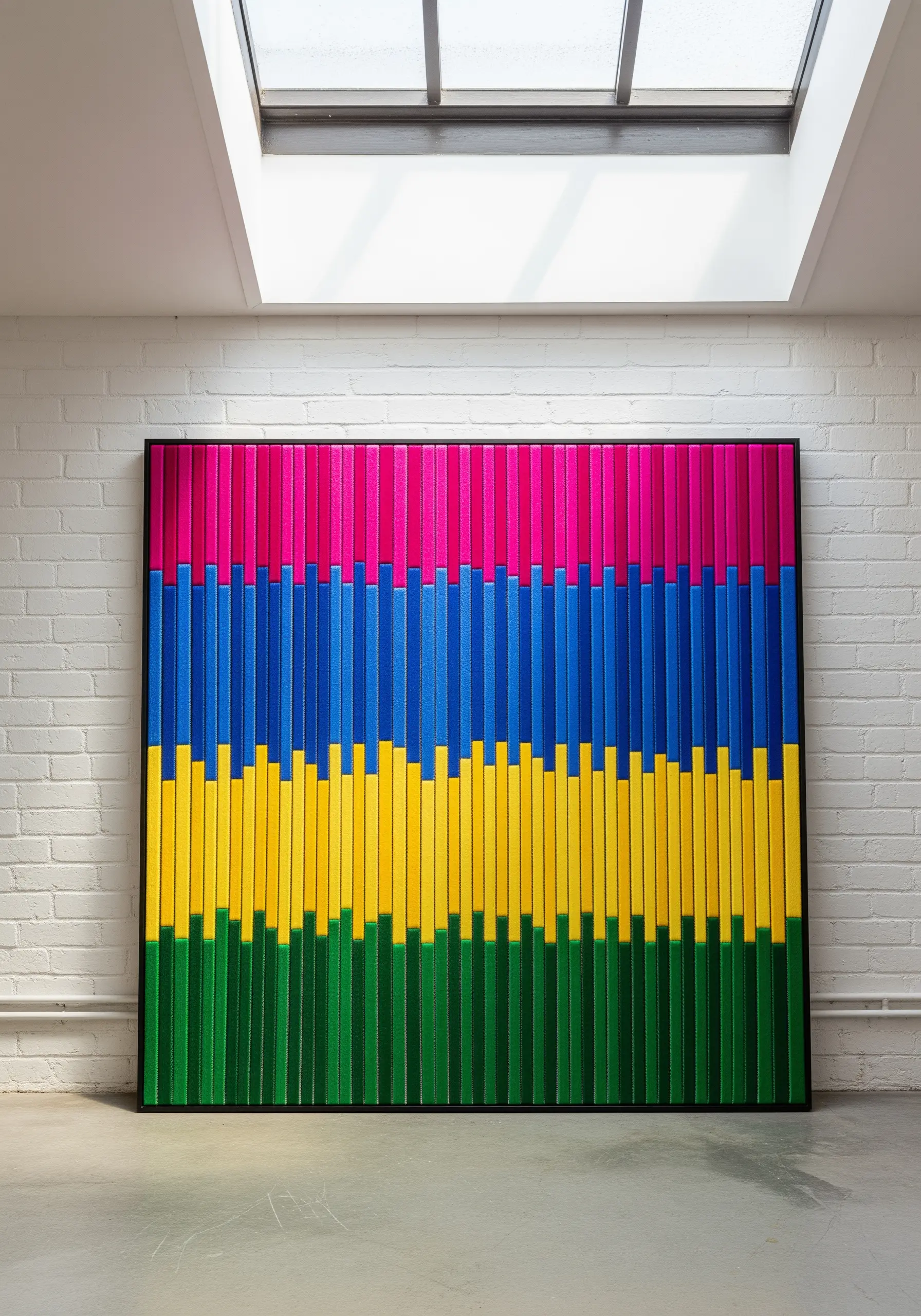 A large, framed textile art piece with colorful layers resembling Mola or reverse appliqué.