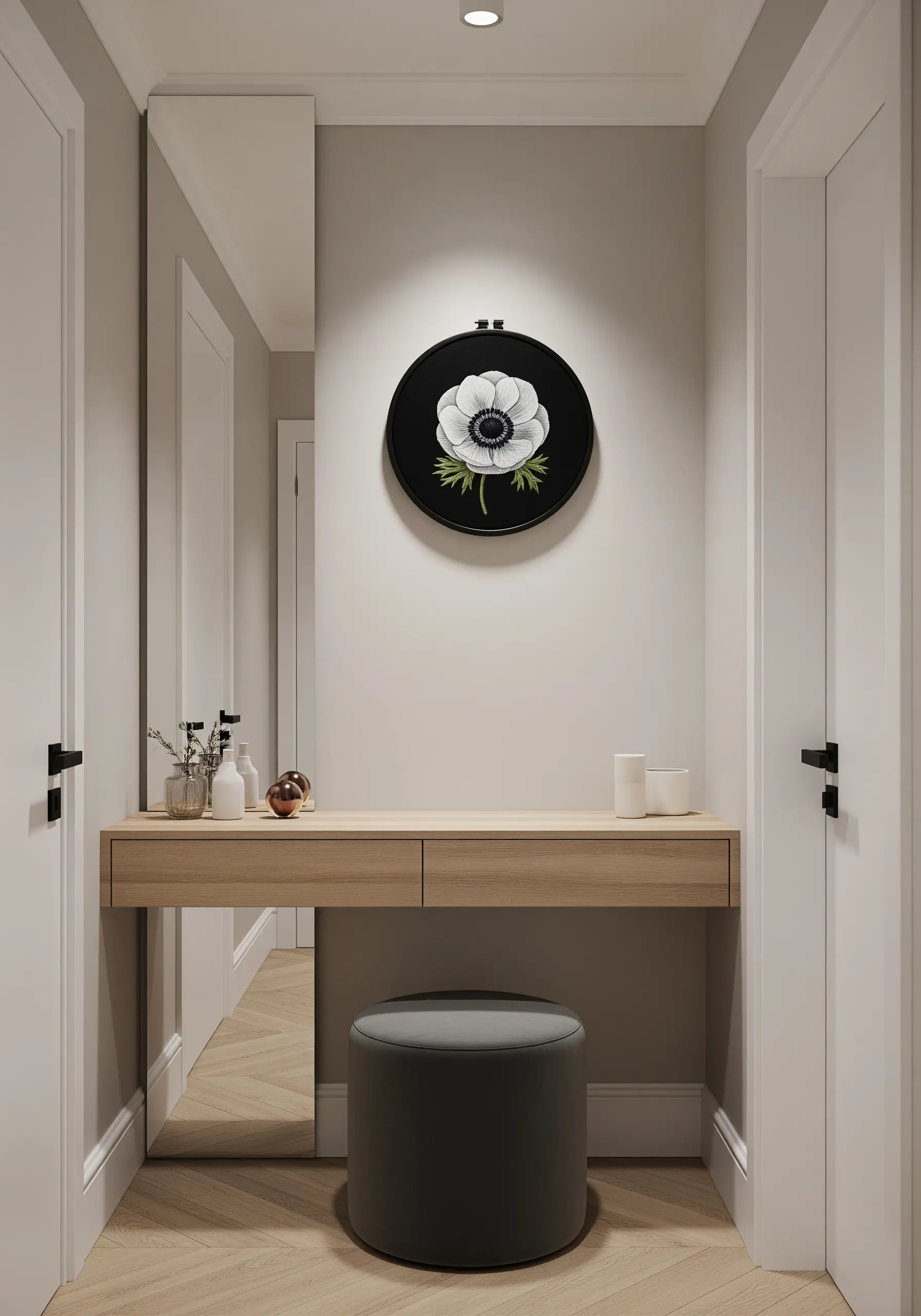 A single, realistic white anemone flower embroidered on black fabric in a black hoop.