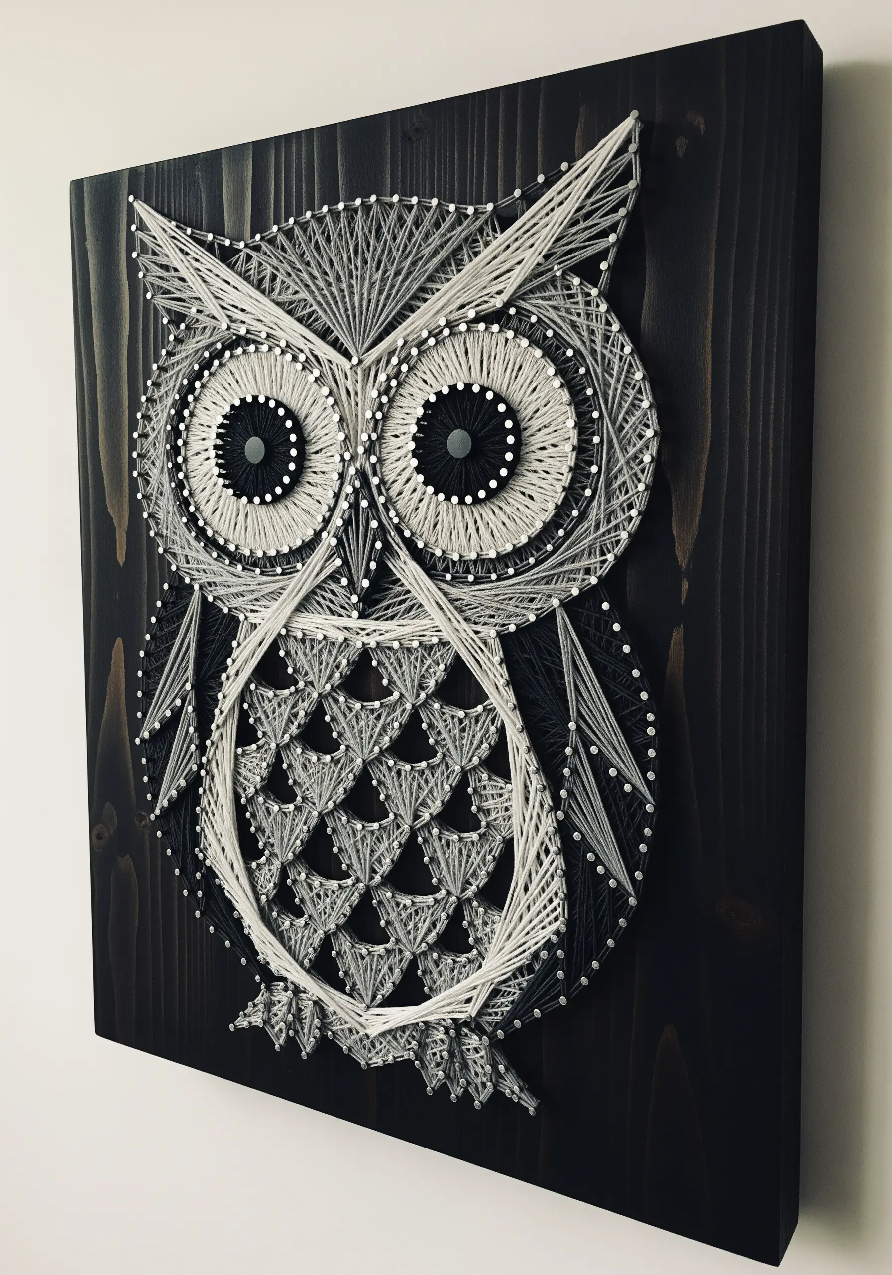 A graphic owl embroidered in black and white, featuring different pattern fills for its body.
