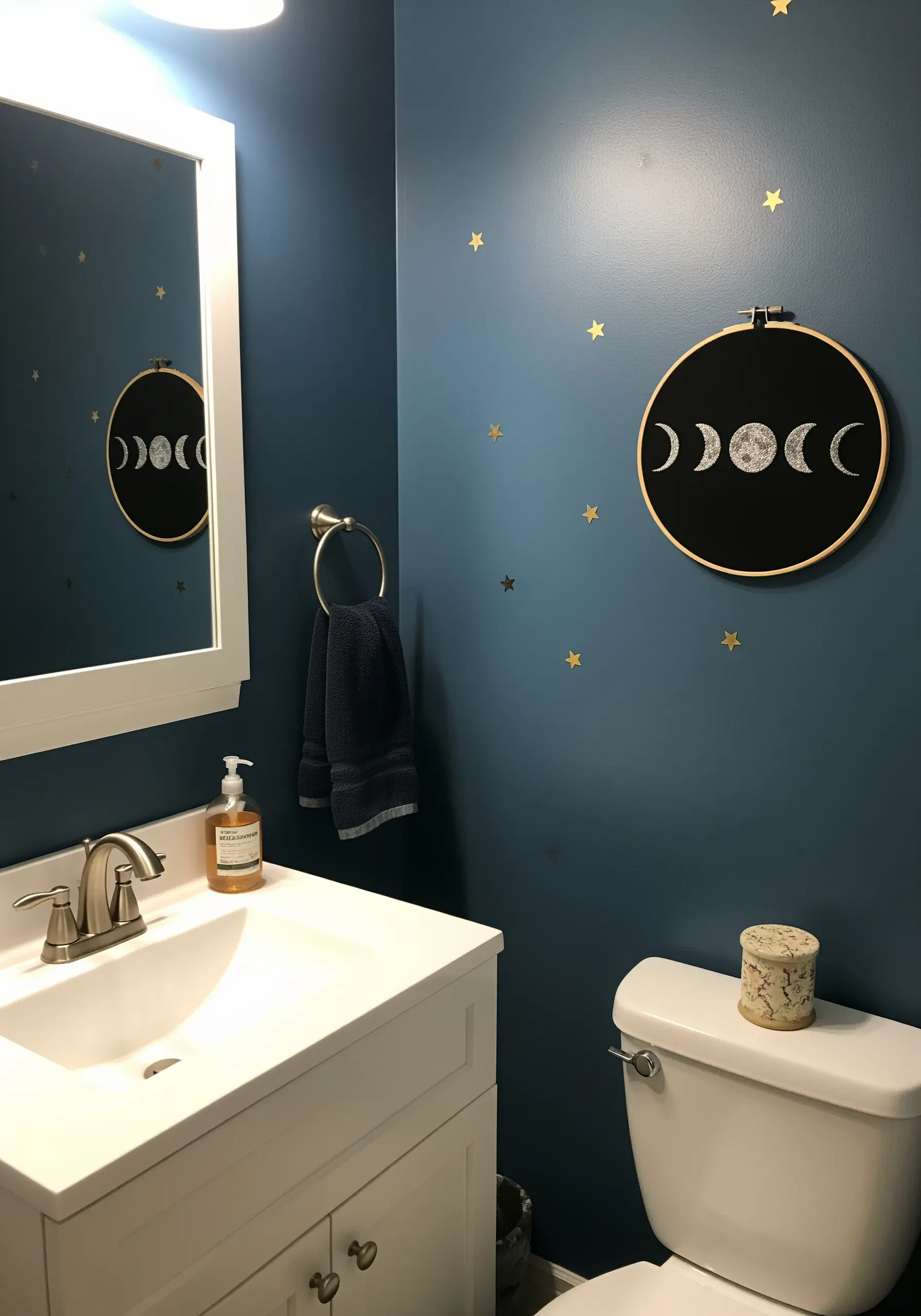 Embroidered moon phases on black fabric, with the full moon highly textured.