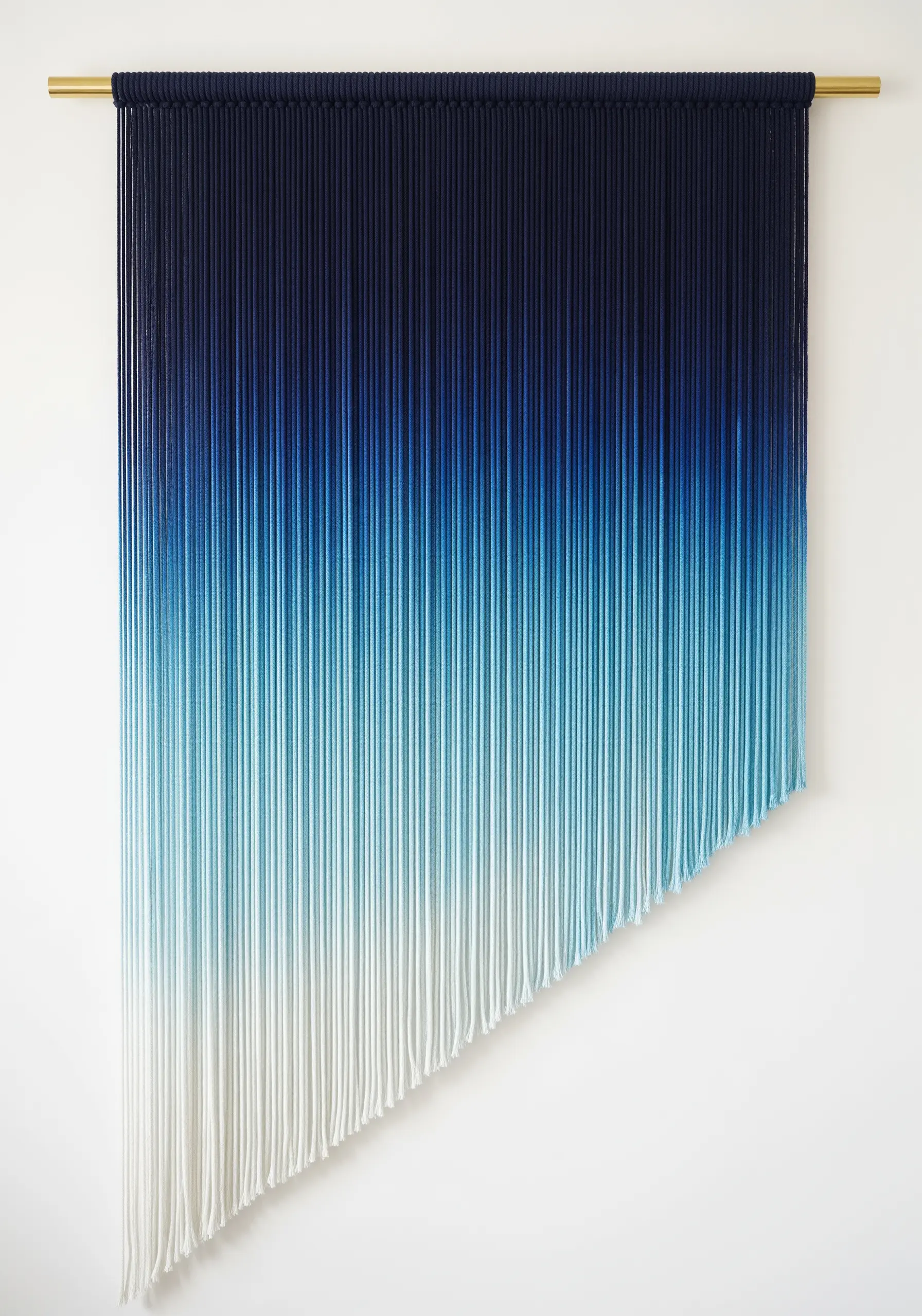 A large wall hanging of dip-dyed cords creating a blue-to-white ombre gradient effect.