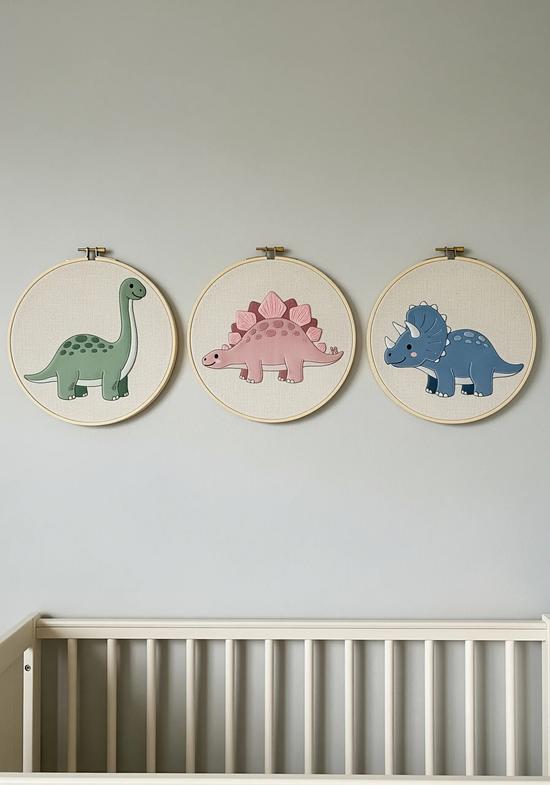 Three embroidery hoops featuring cute, cartoon-style dinosaurs in pastel colors.